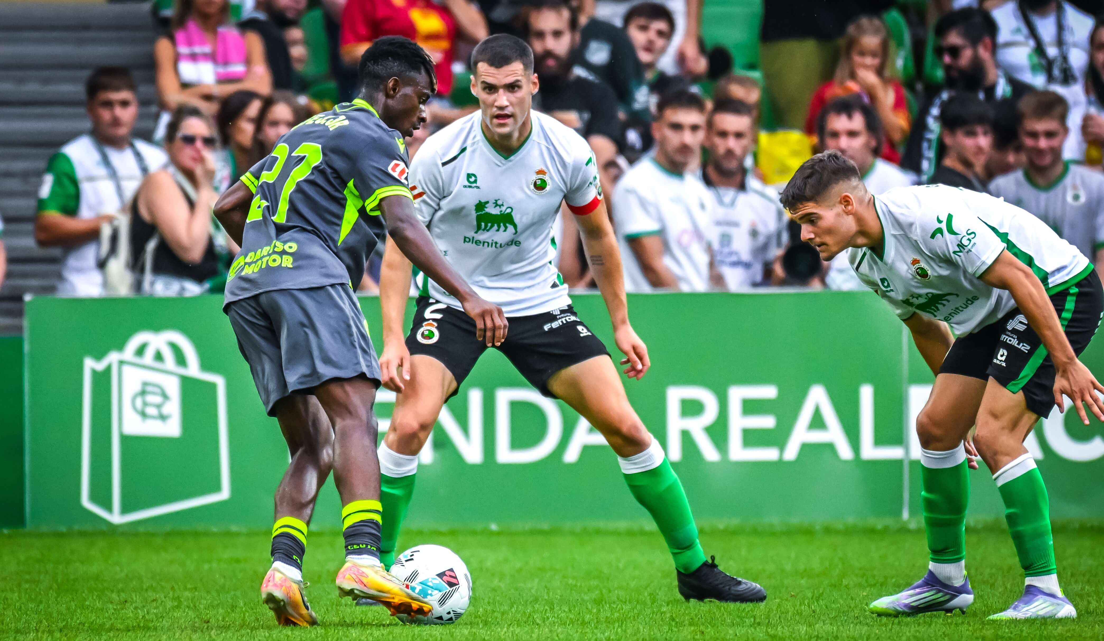 Peio Canales defiende a Ugiagbe en el Racing-Ceuta.