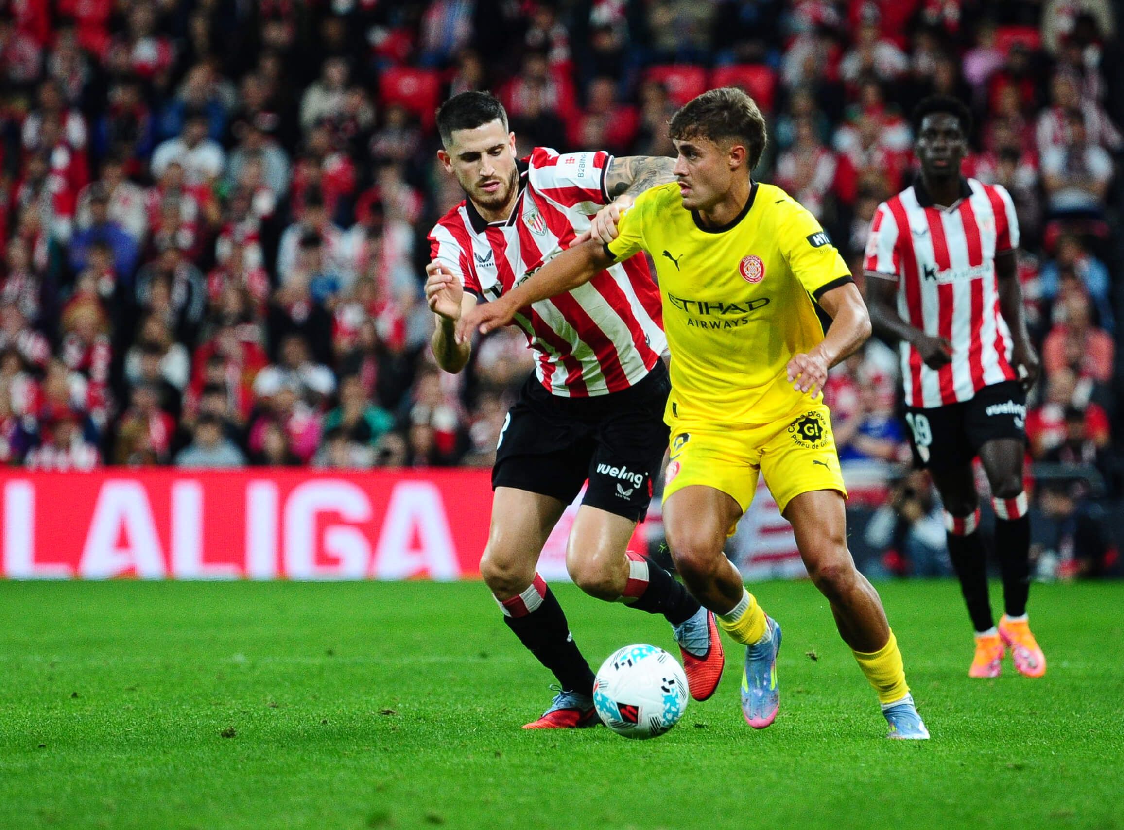 Hugo Rincón pelea un balón con Oihan Sancet en el Athletic-Girona.