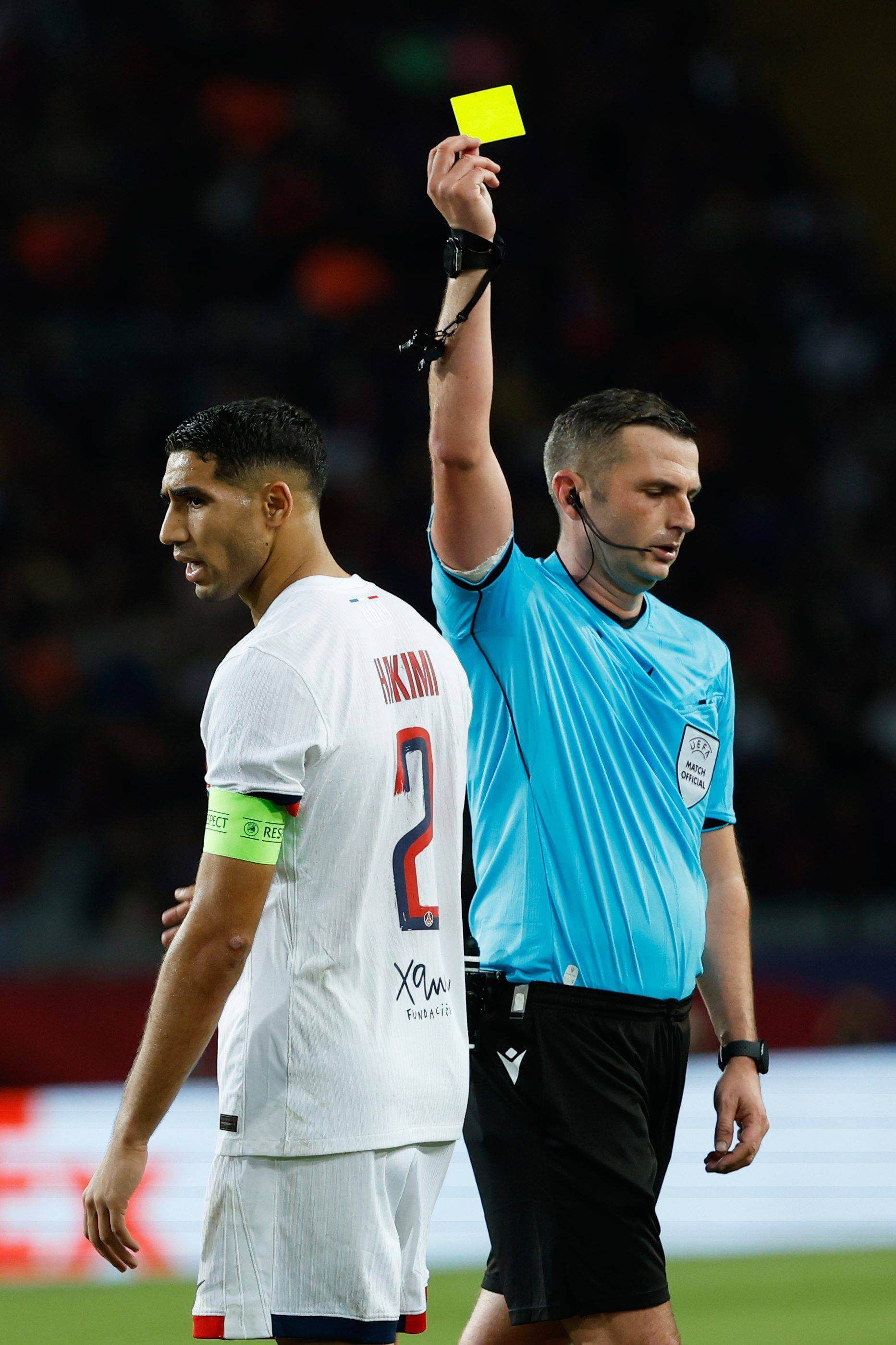 Michael Oliver amonesta a Achraf Hakimi en el FC Barcelona - PSG. Fuente CordonPress.