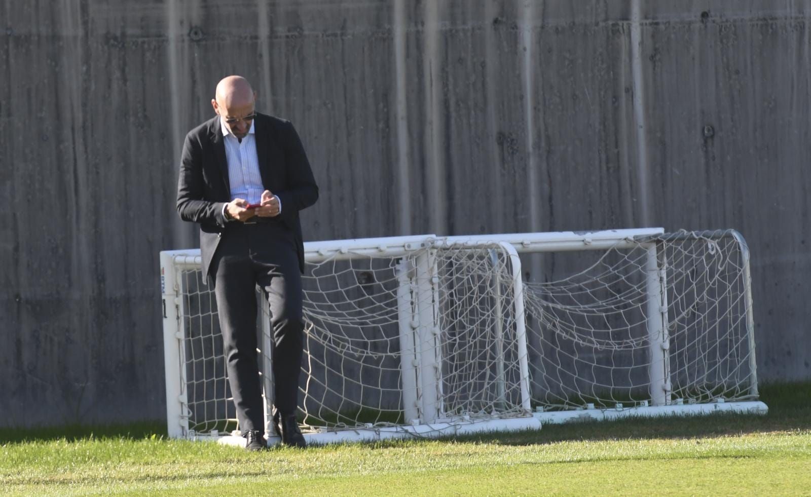 Monchi, atento a su teléfono en un entrenamiento del Sevilla.