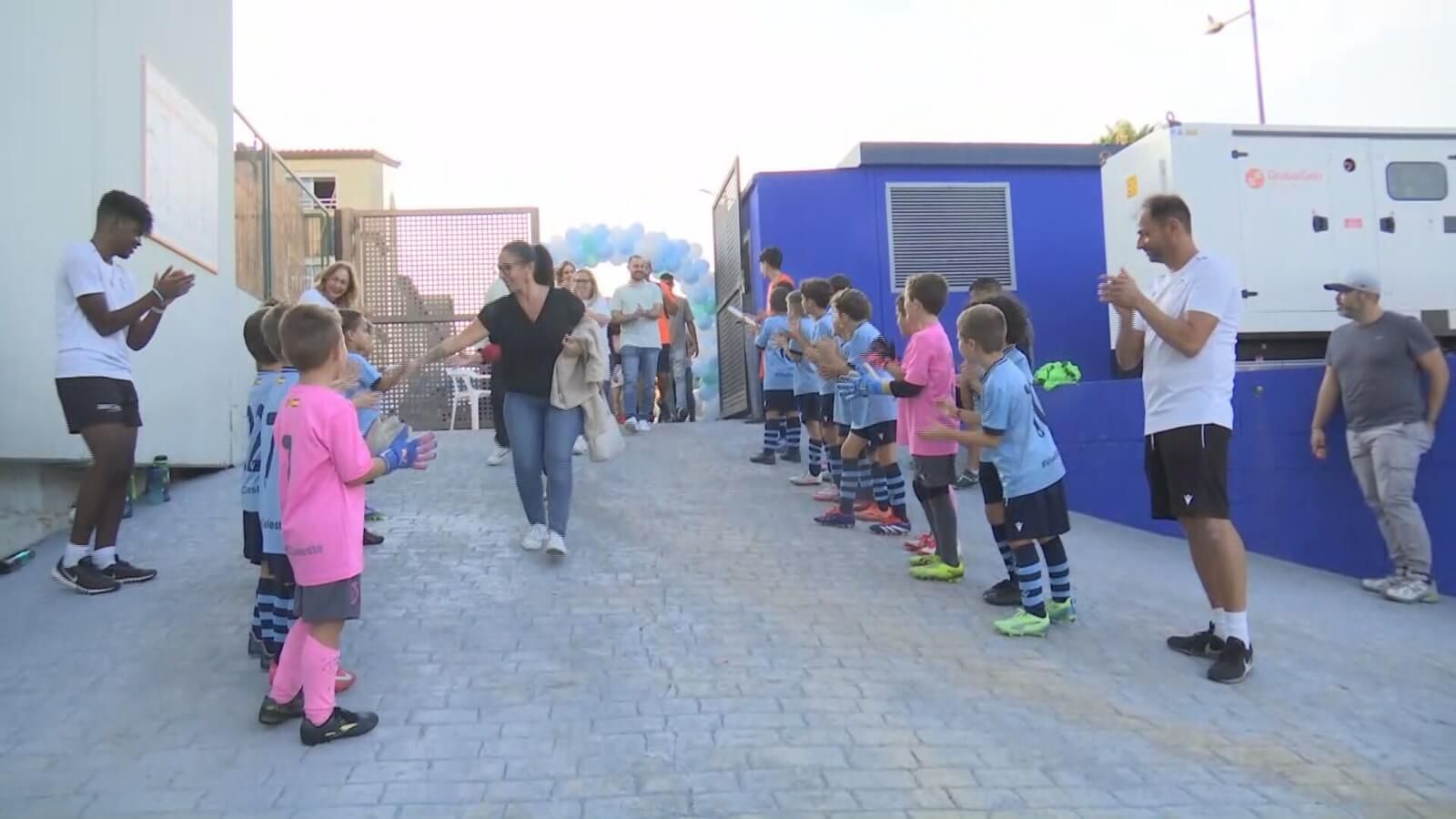 Los niños escoltan a los padres en El Terrer de Paiporta. De fondo, un arco con globos