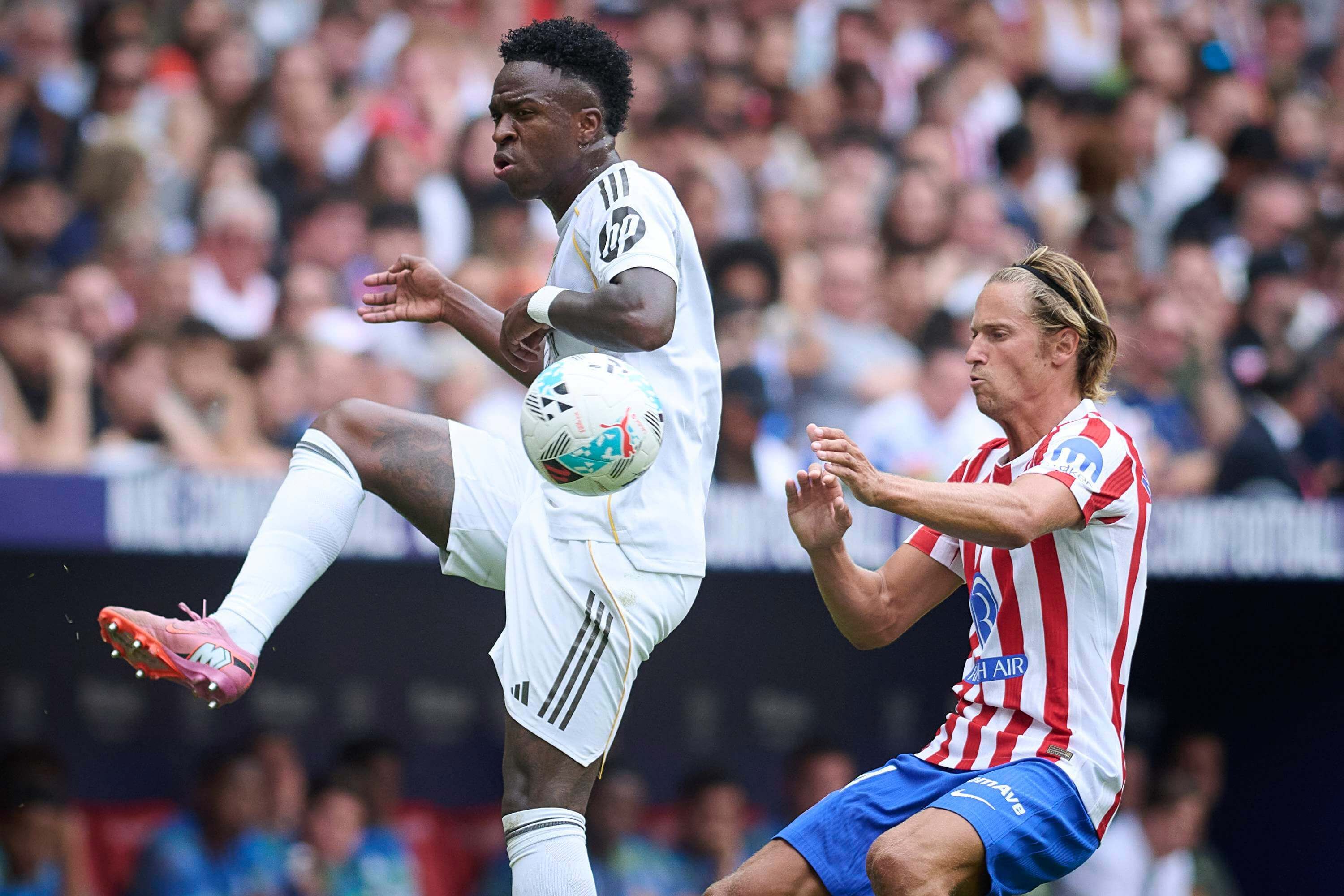  Vinicius Jr. suelta un balón delante de Marcos Llorente en el derbi.