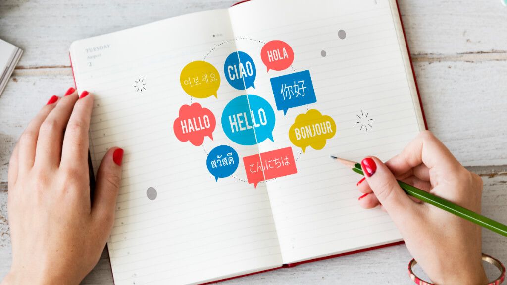 Cuaderno con bocadillos de diálogo con la palabra 'Hola' en diferentes idiomas