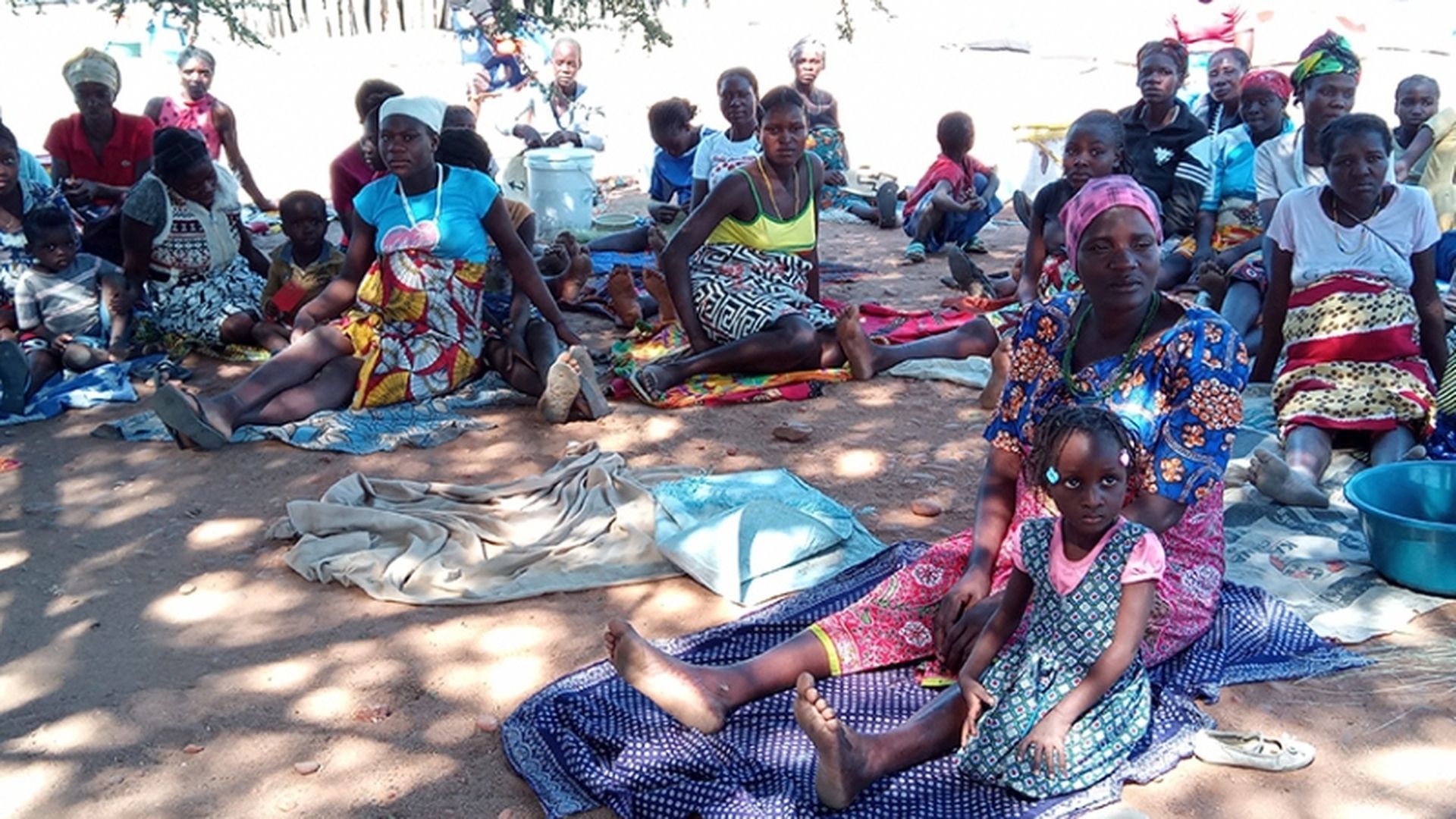 Mujeres y niños se alojan frente al Hospital de Chiulo,Ombadja , en espera de atención sanitaria