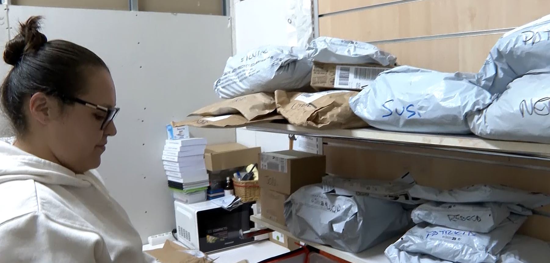 Carla organiza los paquetes en la trastienda de su papelería