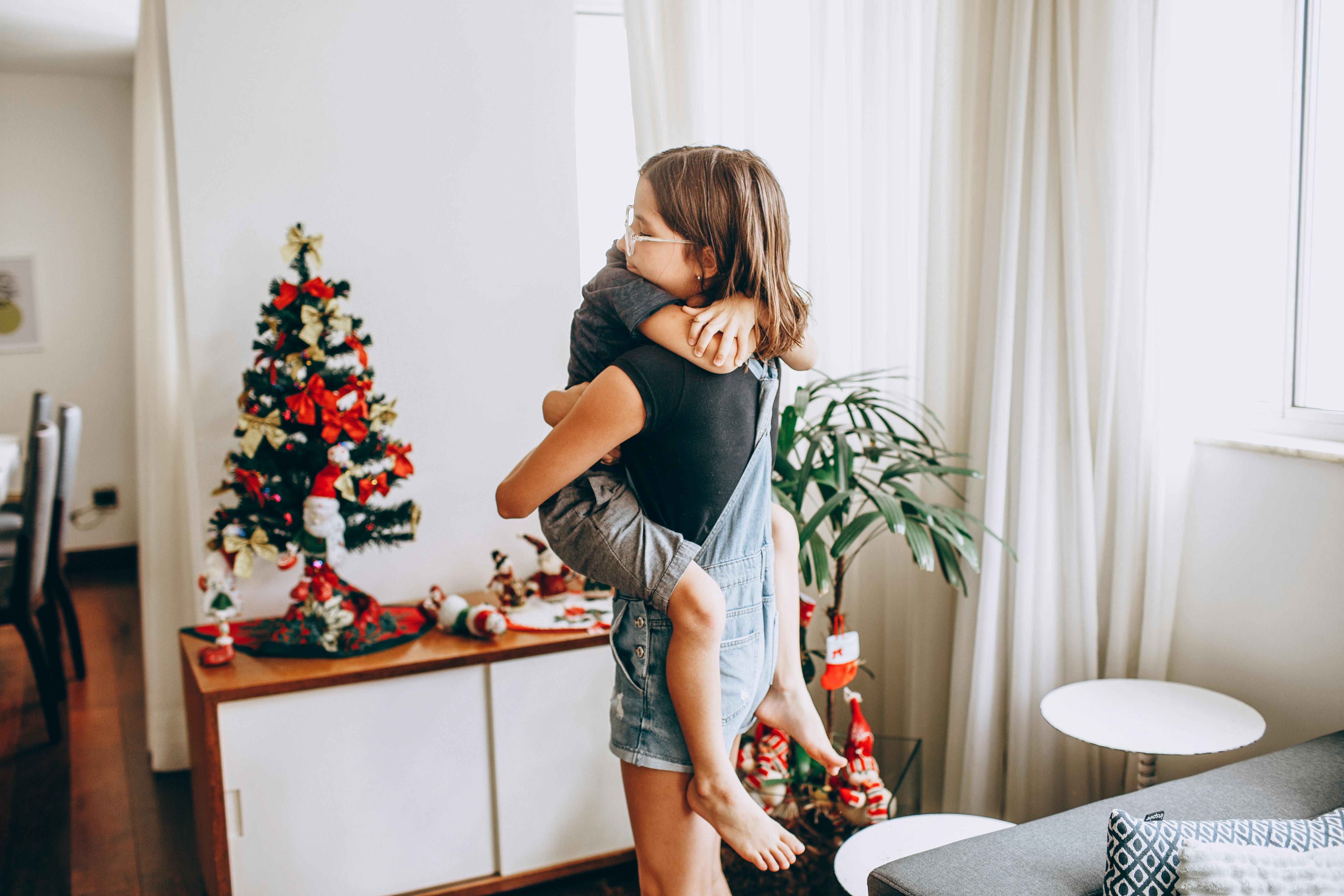 Dos hermanos abrazándose con decoración navideña al fondo