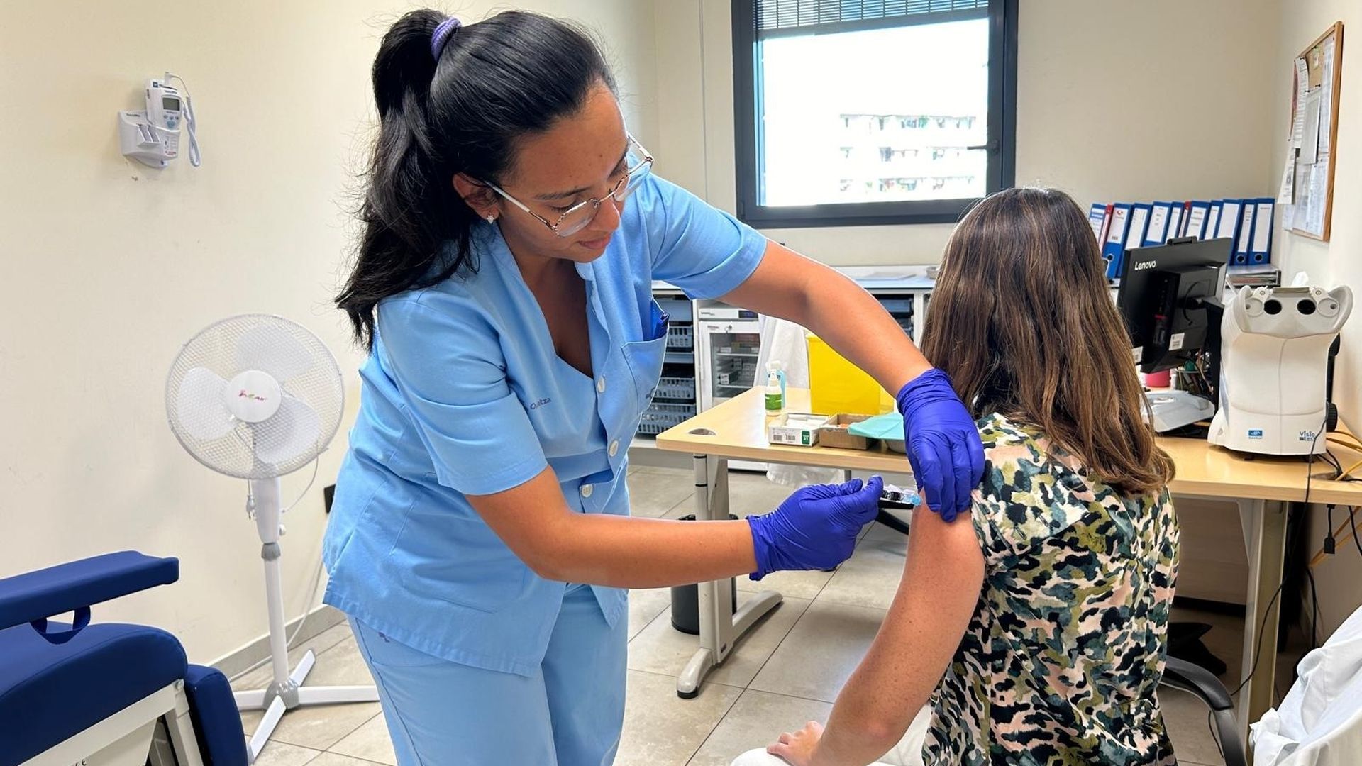 Una enfermera vacunando a una paciente