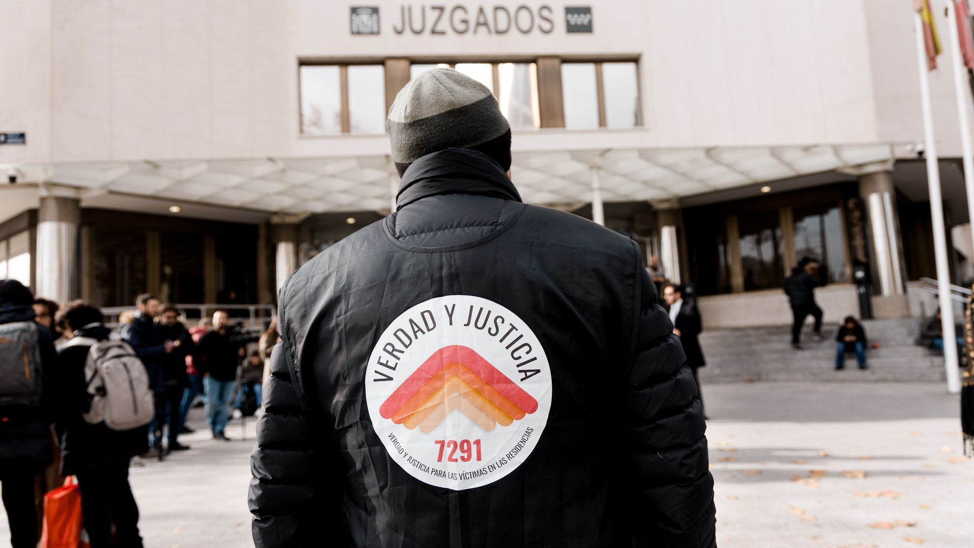 Una persona protesta por las victimas de las residencias durante la pandemia en los juzgados de Madrid