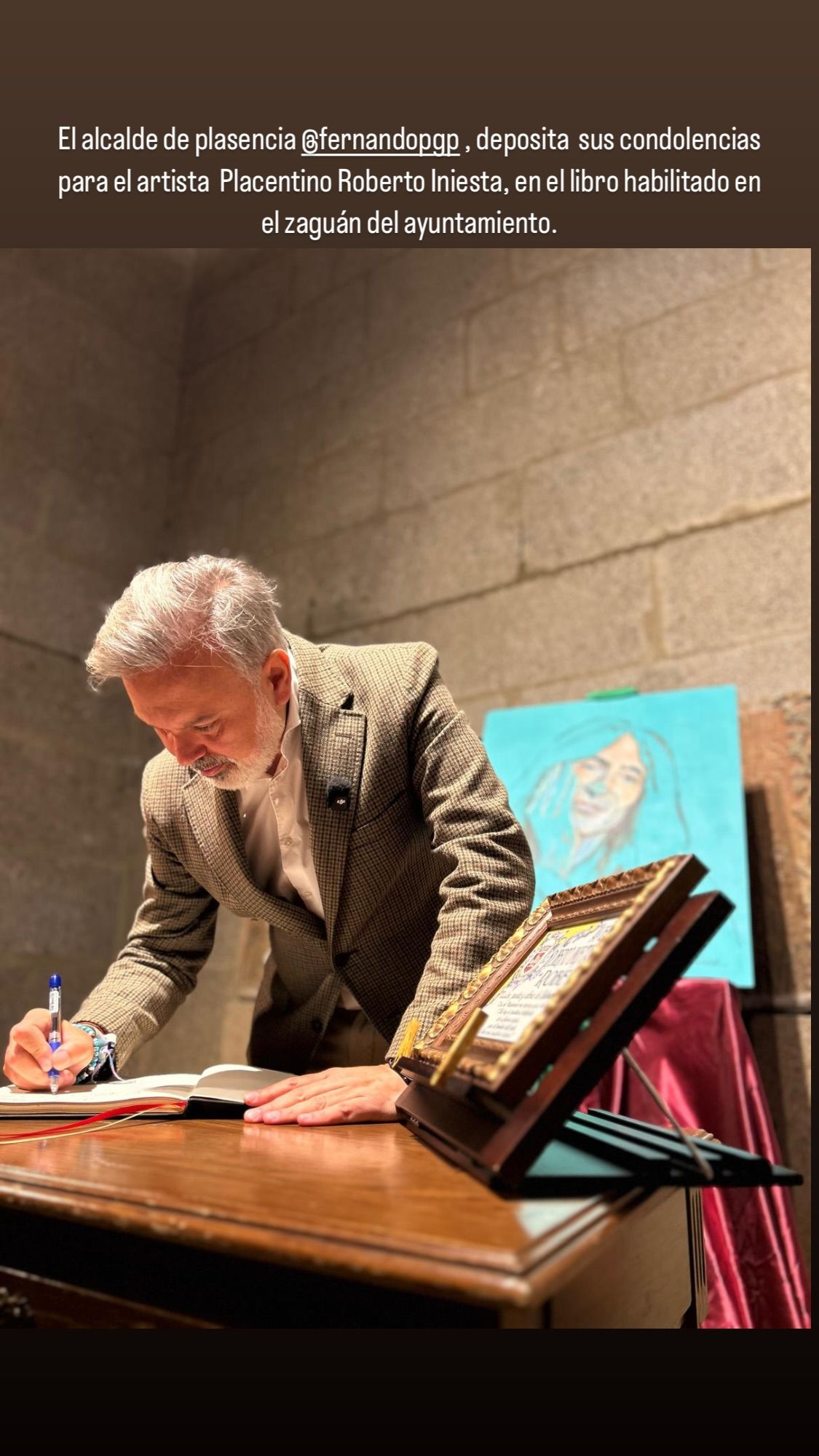Imagen del alcalde de Plasencia firmando el libro de condolencias habilitado en el municipio por la muerte de Robe Iniesta