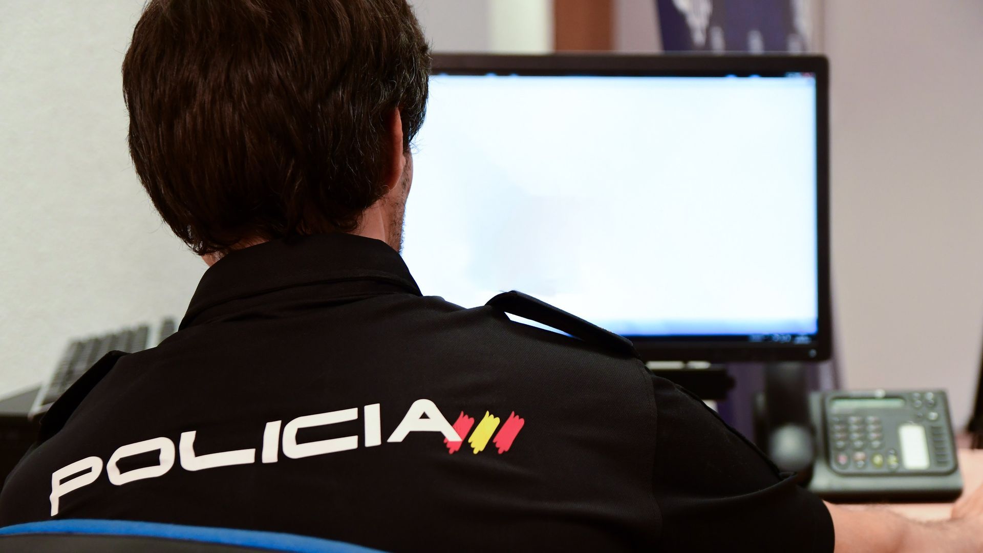 Agente delante de un ordenador de mesa