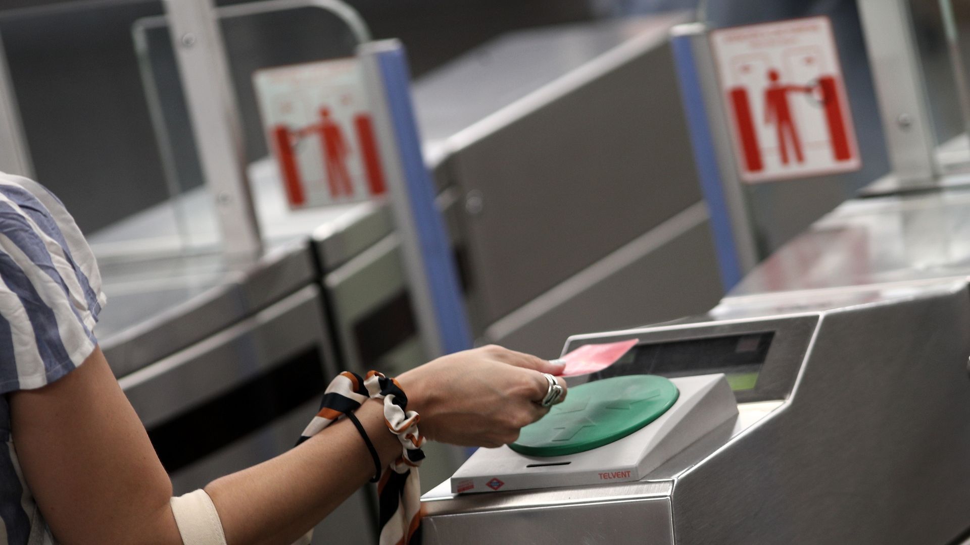 Una mujer pasa su billete en el torno del Metro Plaza de España, en Madrid