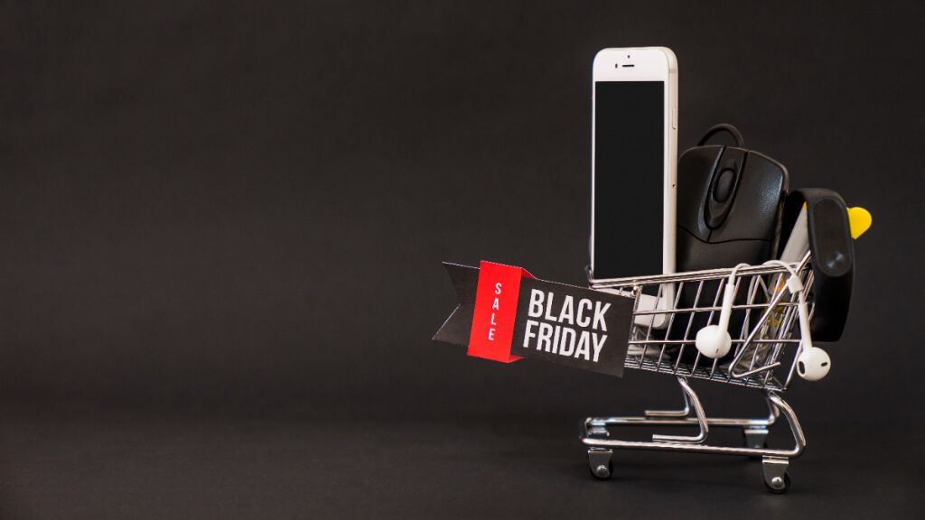 Carro con diferentes dispositivos electrónicos y un cartel de 'black friday' (Freepik)
