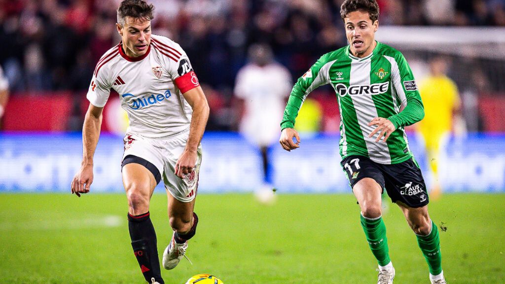 Azpilicueta y Riquelme pugnan en carrera en el derbi sevillano.