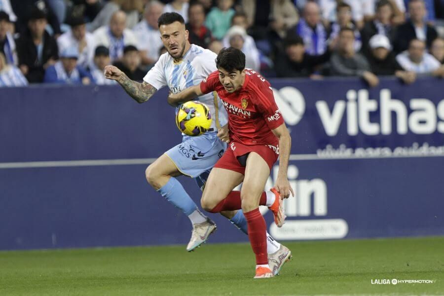  Dioni trata de llevarse el balón en el Málaga-Zaragoza de la 24/25.