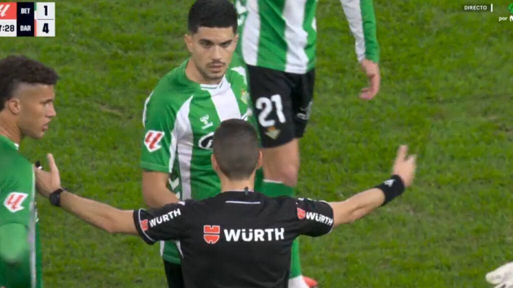  El árbitro, explicándole la acción a Marc Bartra.