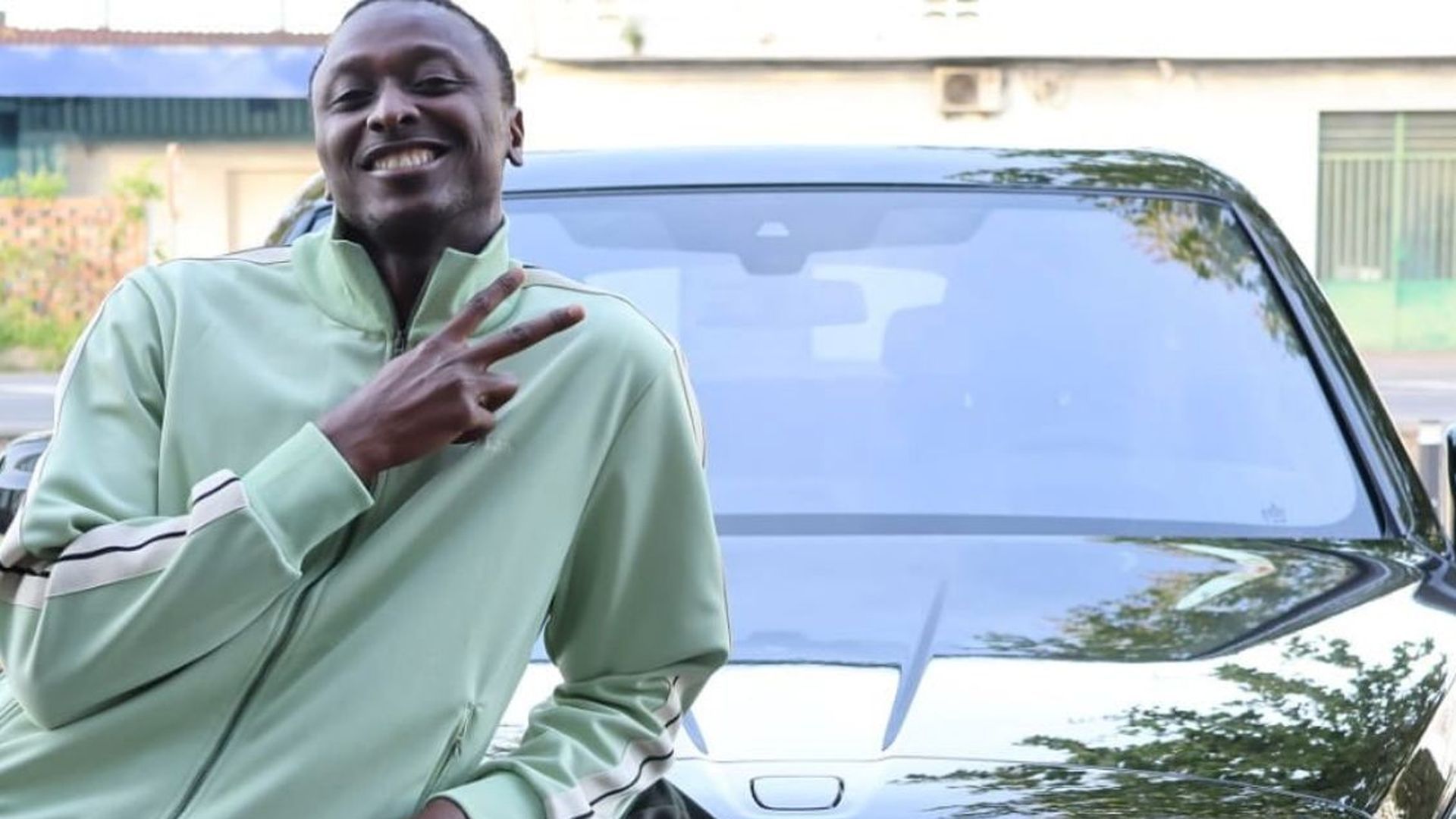 Sadiq, sonriente junto a su coche