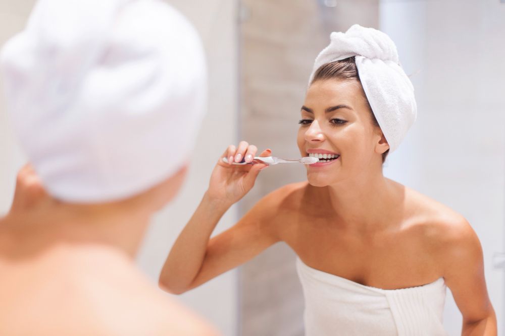 Mujer cepillándose los dientes con un cepillo manual