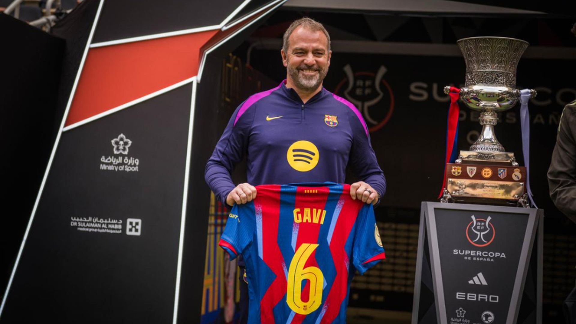 Hansi Flick posando con la camiseta de Gavi antes de la final