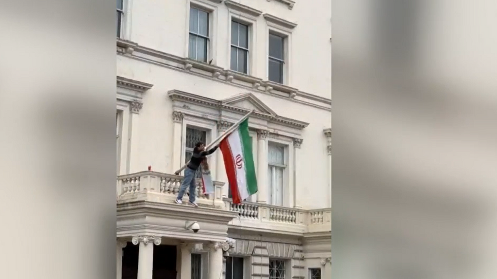 Un hombre trepa al balcón de la embajada iraní y arranca la bandera de la Revolución Islámica durante una protesta en Londres