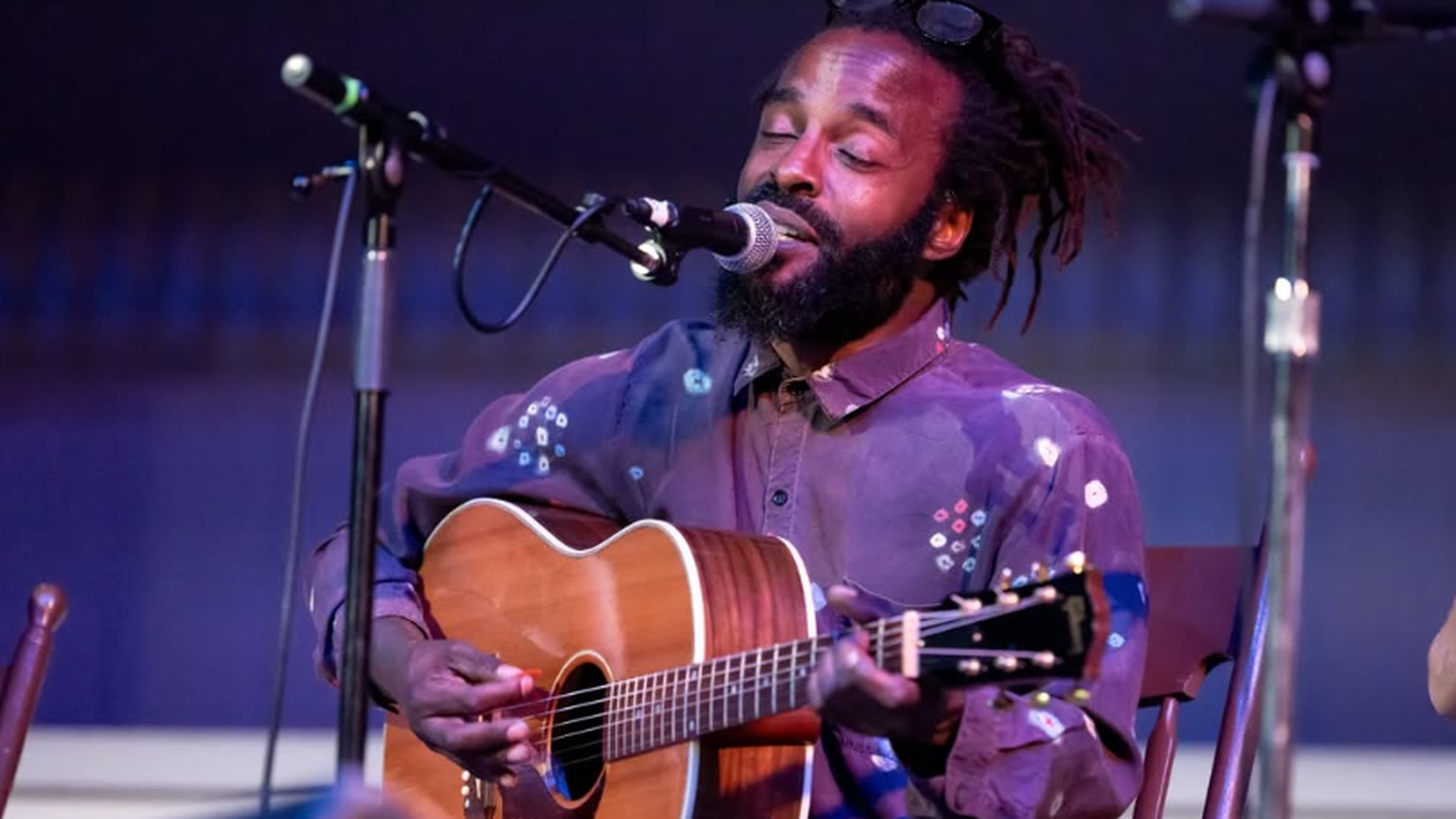John Forté tocando la guitarra durante un concierto