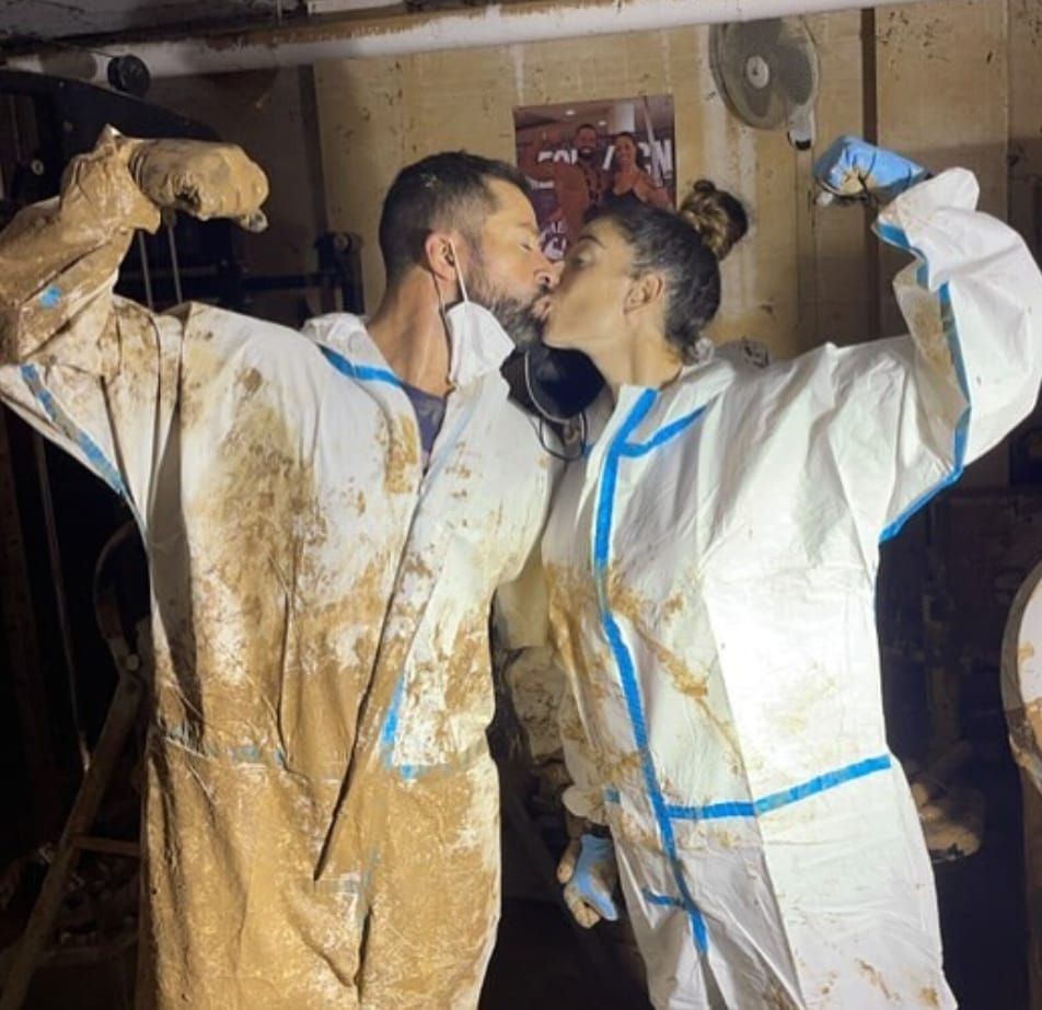 Miguel Ángel y su mujer quitando barro de su gimnasio