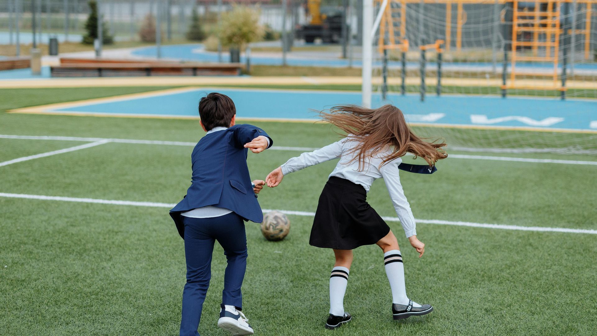 Niños jugando a fútbol en el colegio