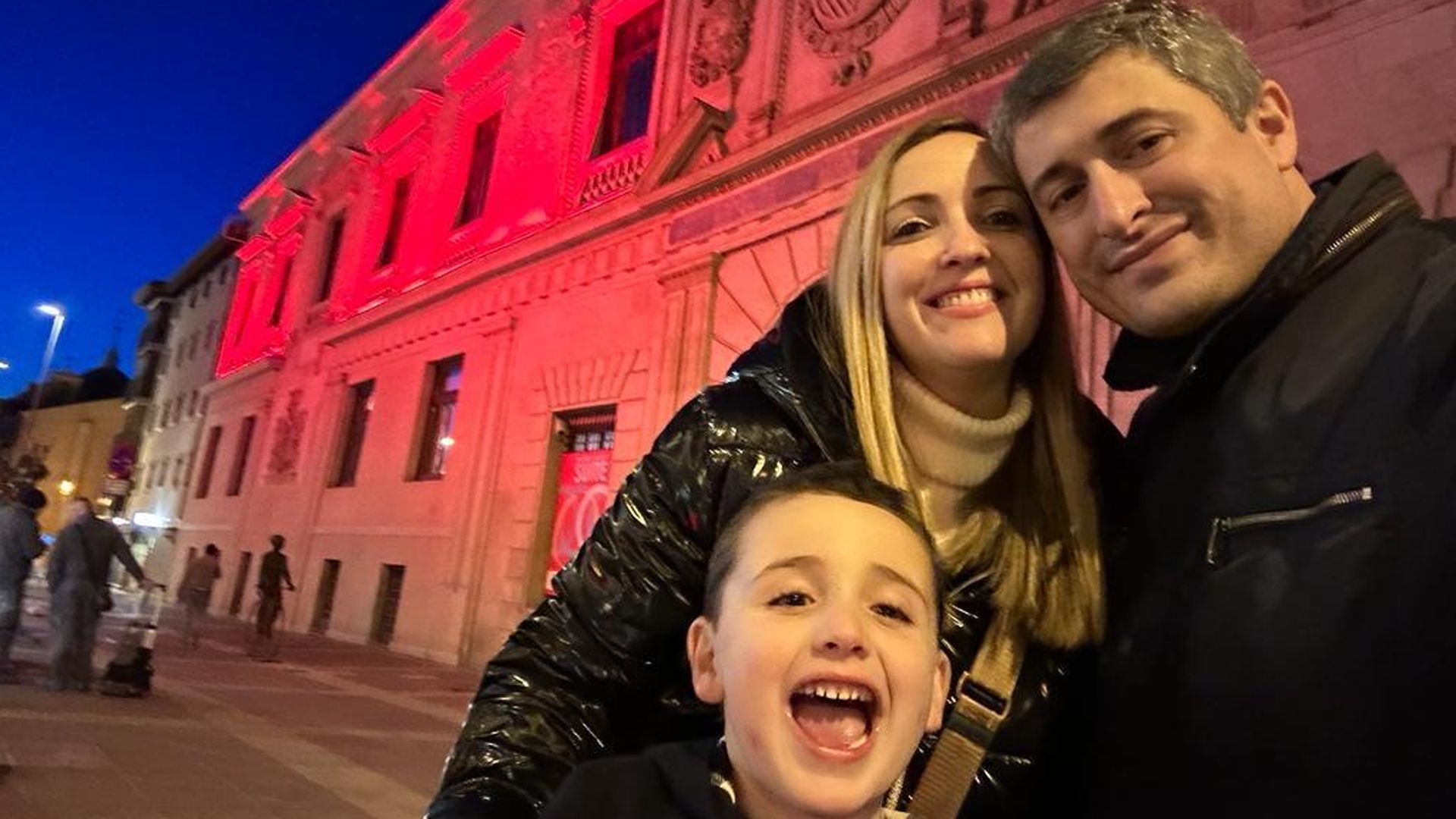 Emilio, junto a su familia, durante el Día Mundial de la Enfermedad de Kawasaki, con un monumento iluminado de rojo en señal de concienciación