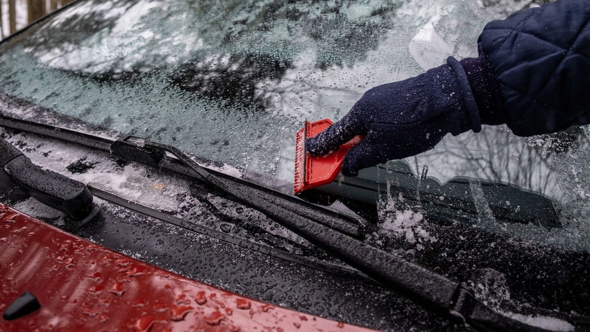 Retirando el hielo del parabrisas Retirando el hielo del parabrisas