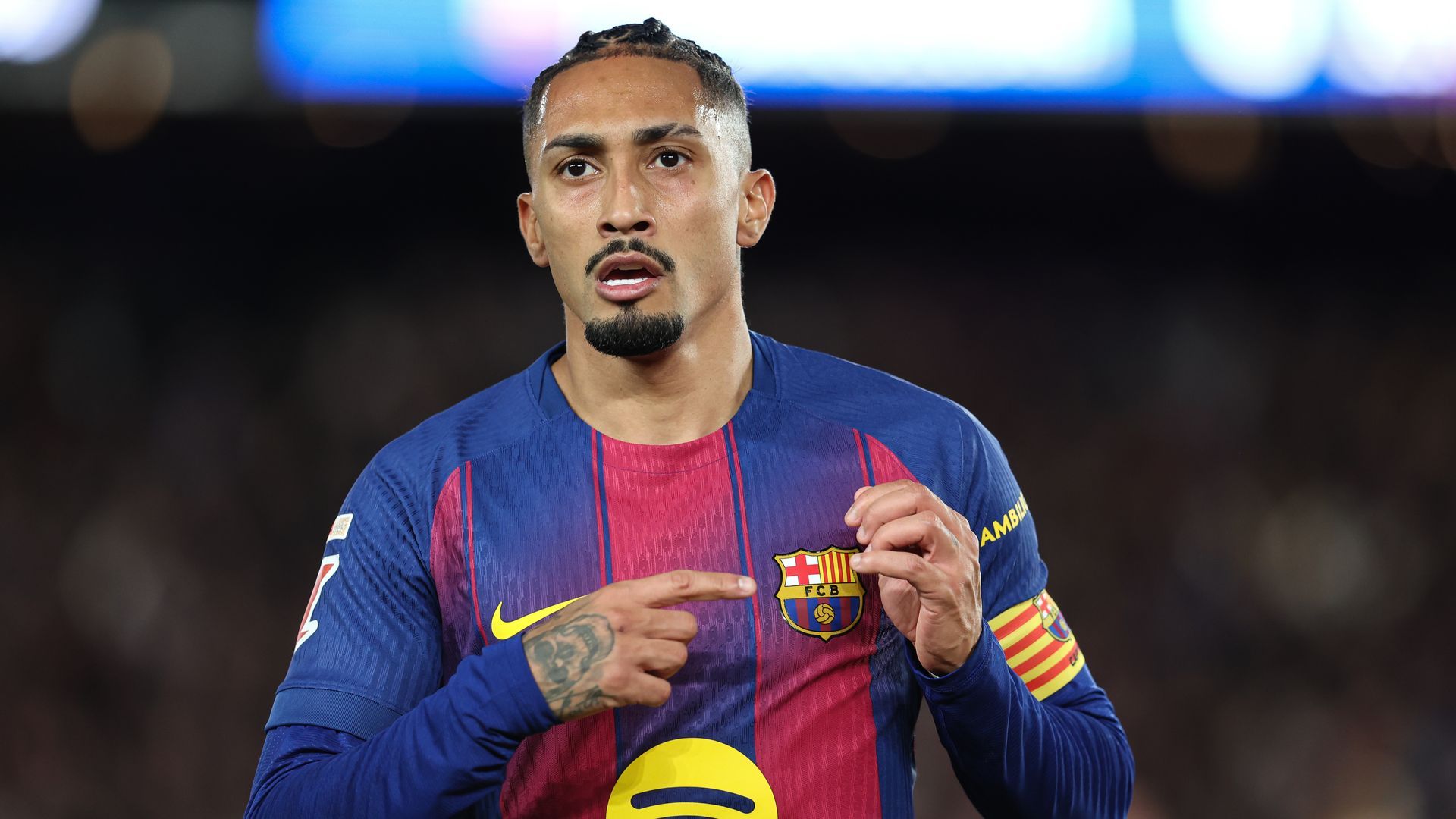 Raphinha señalando el escudo del Barcelona