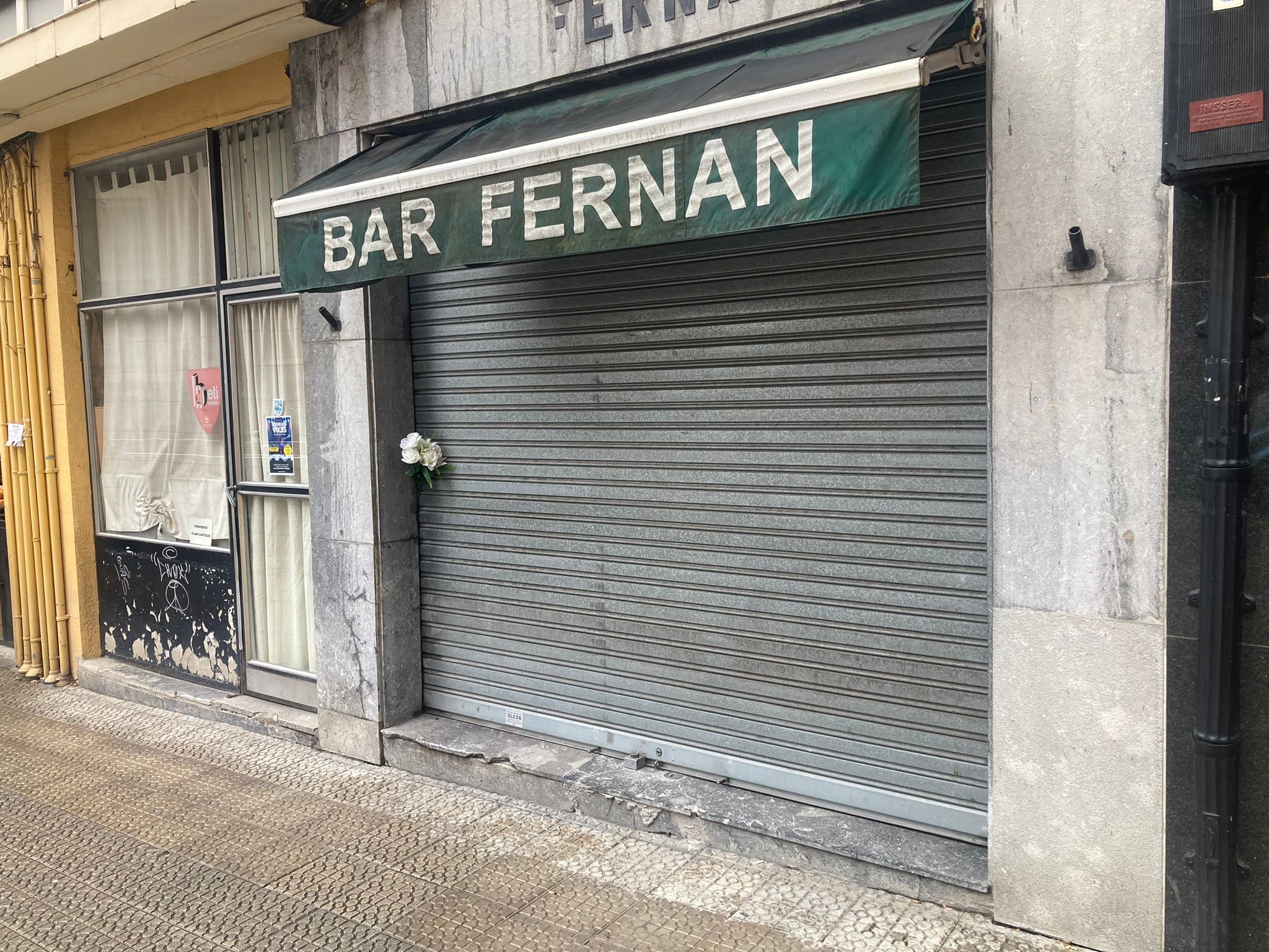 Luis, la víctima, regentaba este bar en el que han depositado flores tras conocerse su muerte