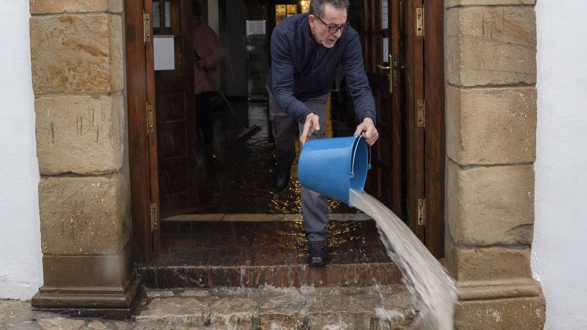 Un hombre achicando agua en Grazalema