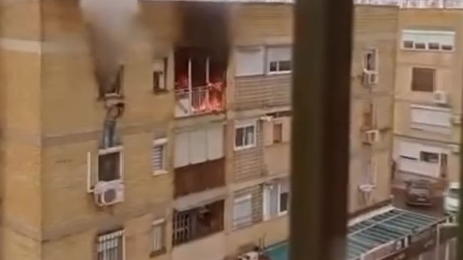 Momento en que la mujer cuelga desde la ventana