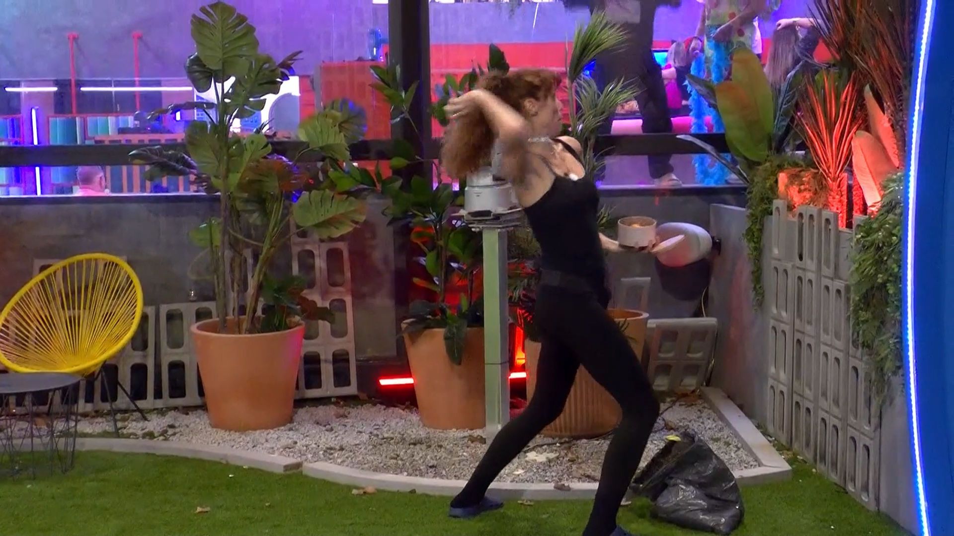 Cristina tira varios huevos por encima de la valla de la casa