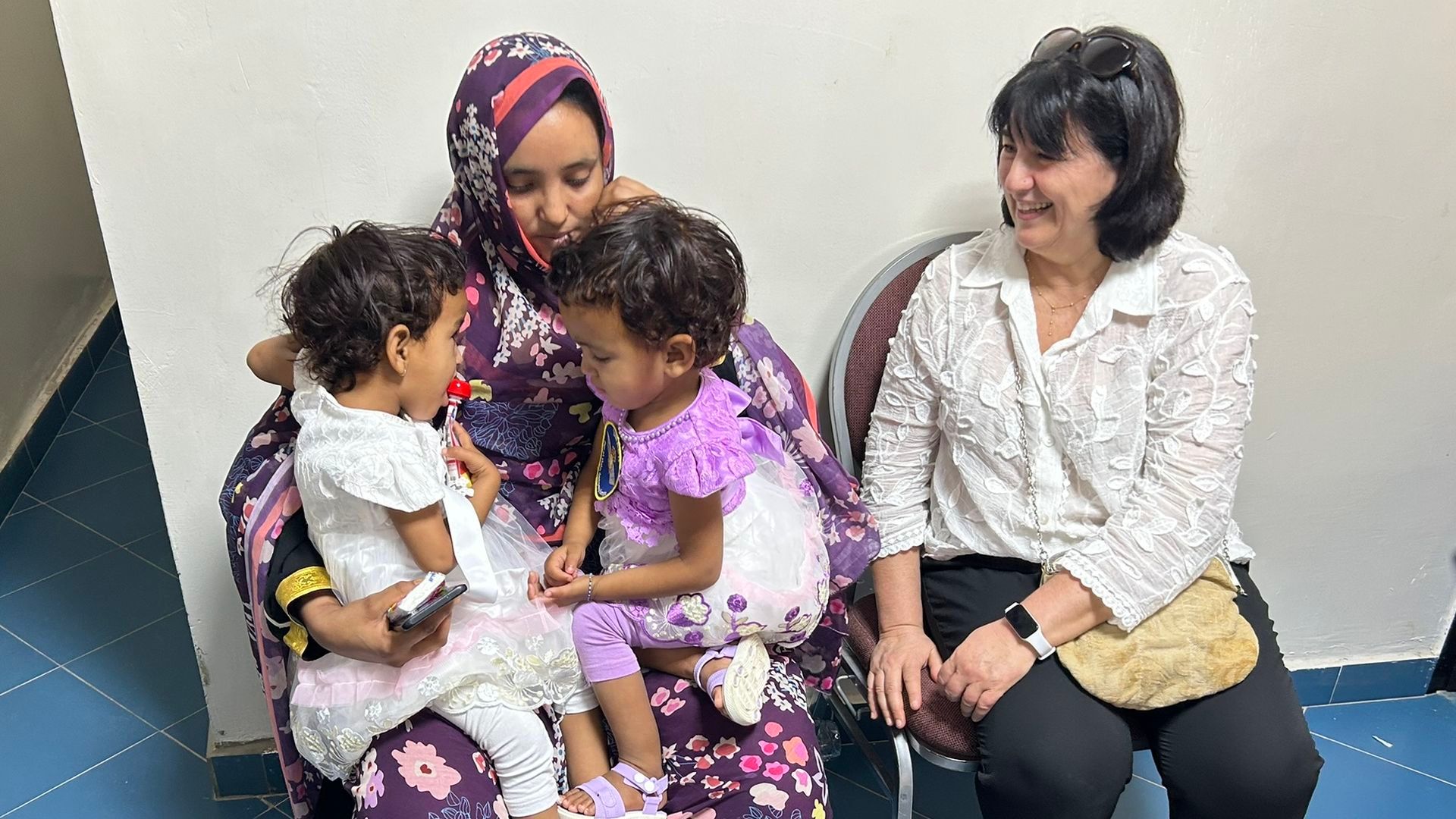 Las gemelas Khadija y Cherive con su madre y la enfermera neonatal, Patrícia Romero