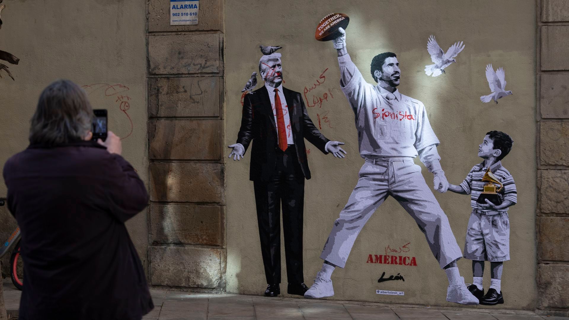 Un grafiti con la imagen de Bad Bunny junto al niño Liam reivindica en Barcelona la paz frente a Trump