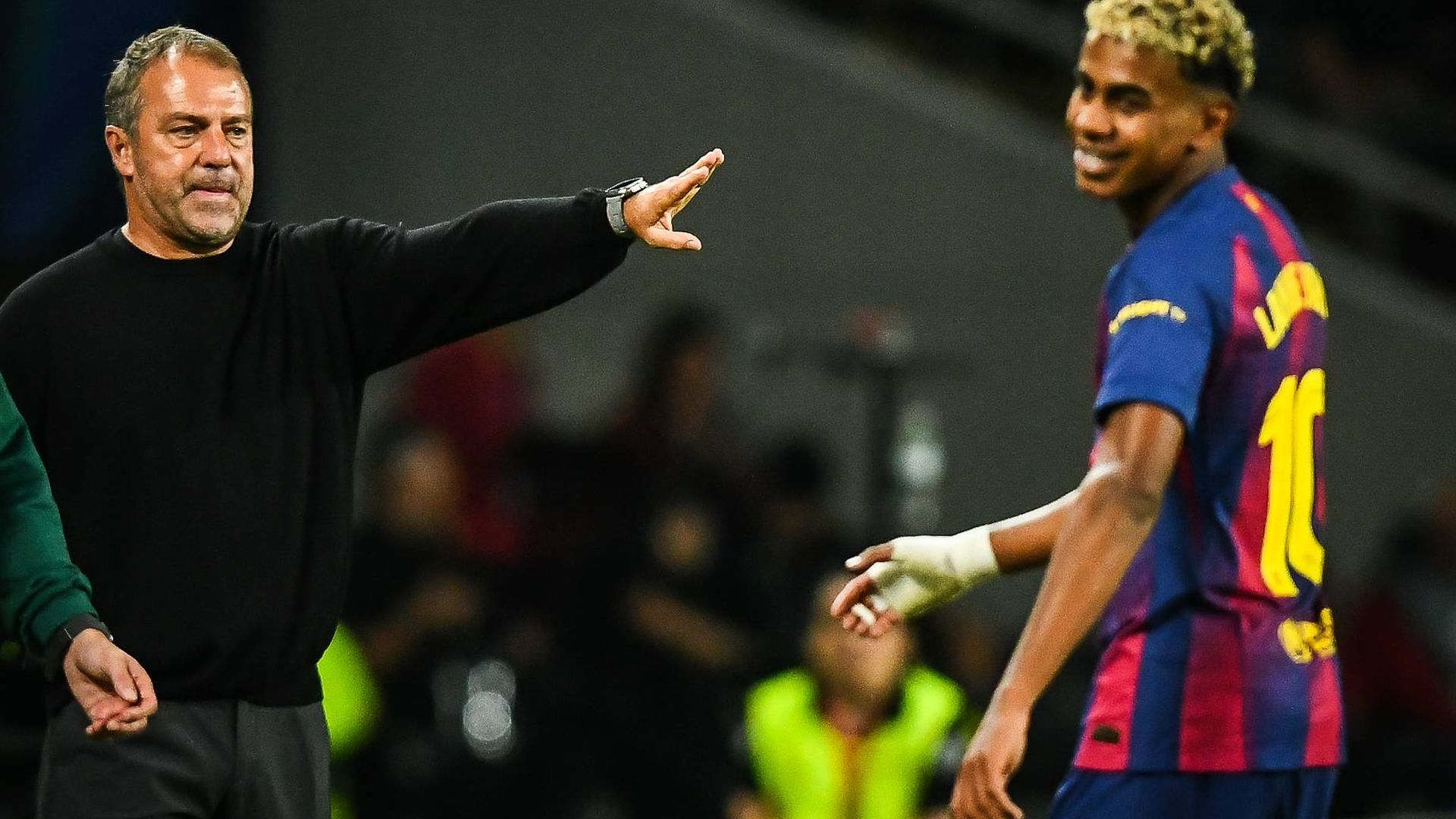 Hansi Flick da instrucciones; a la derecha, Lamine Yamal