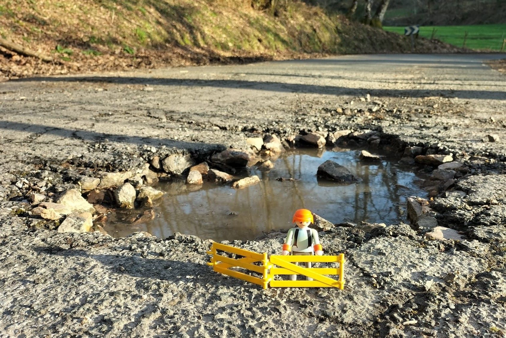 Un operario de Playmobil marcando un bache con unas vallas: la respuesta ingeniosa a una situación desesperada