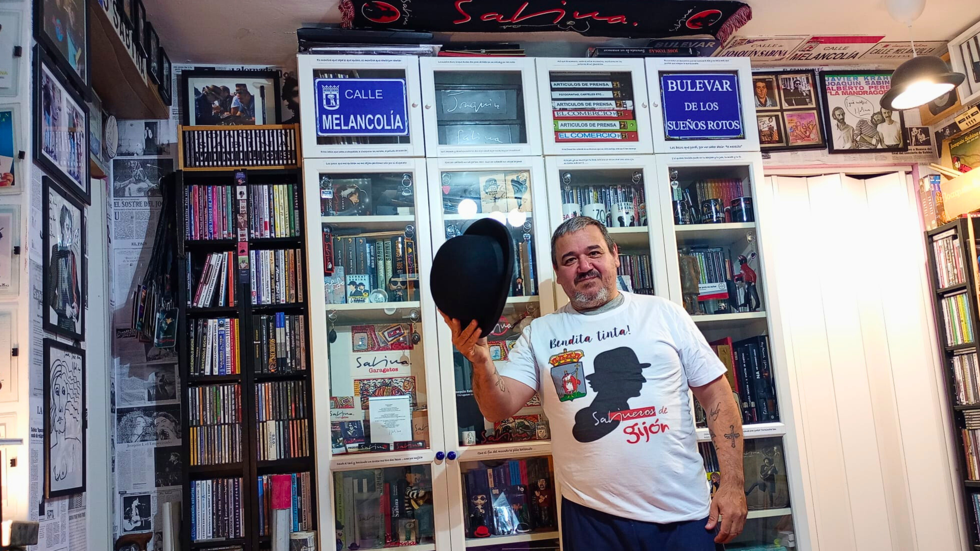 José Luis posa con el bombín original de Sabina y su colección al fondo