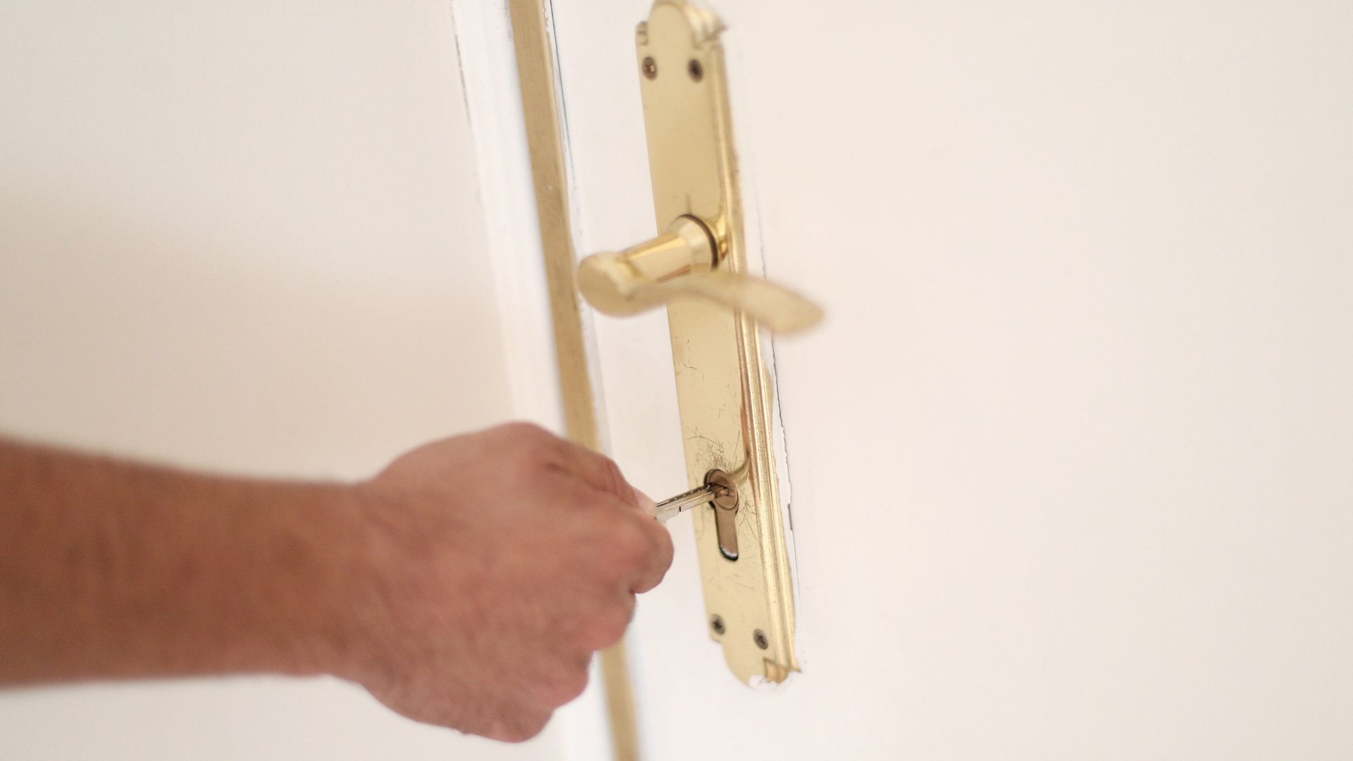 Archivo - Un hombre introduce una llave en la cerradura de la puerta de una vivienda.