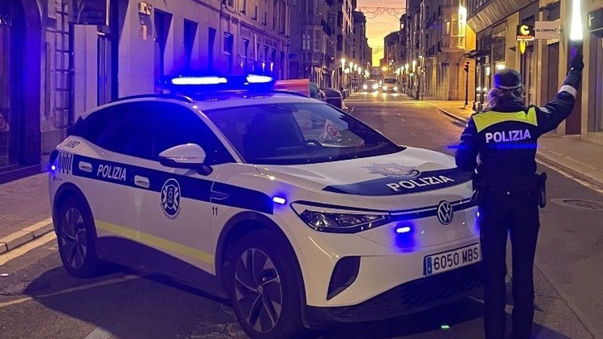 Una agente junto a un coche policial en Vitoria, Álava Una agente junto a un coche policial en Vitoria, Álava