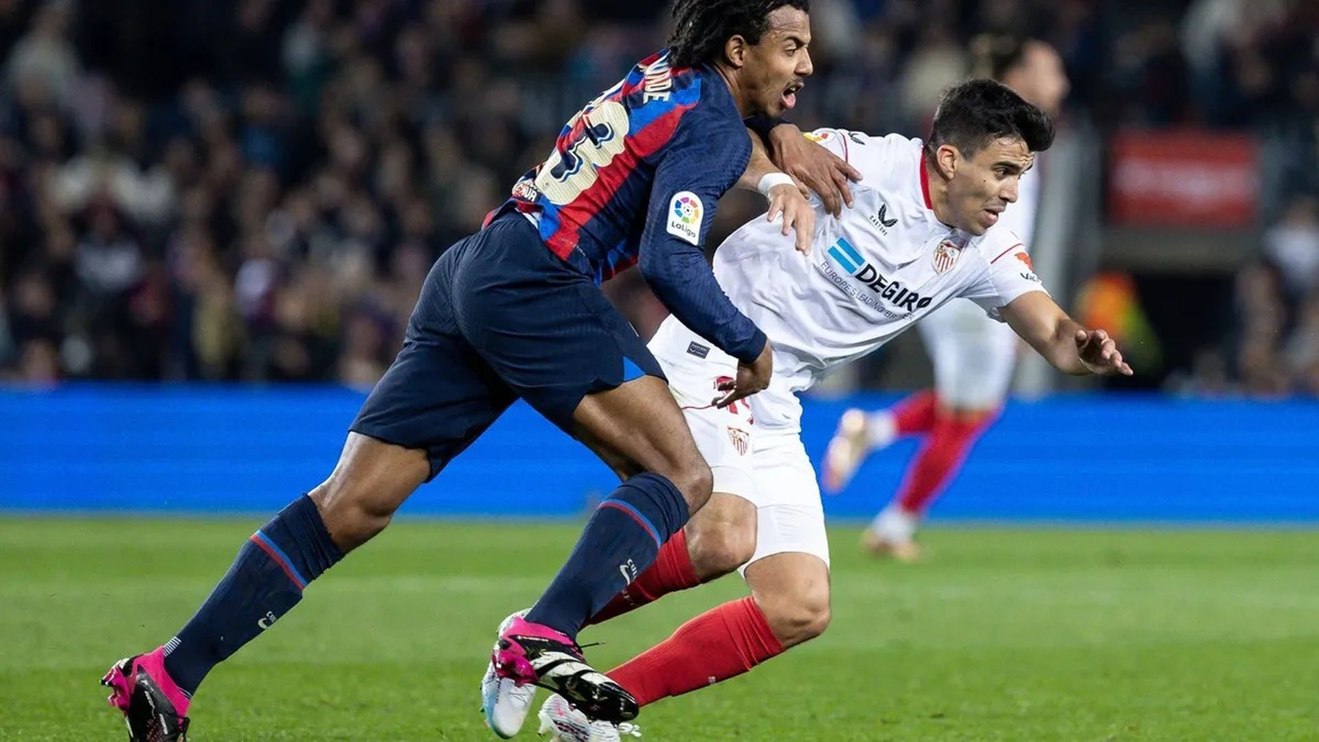 Acuña pugna con Koundé por un balón
