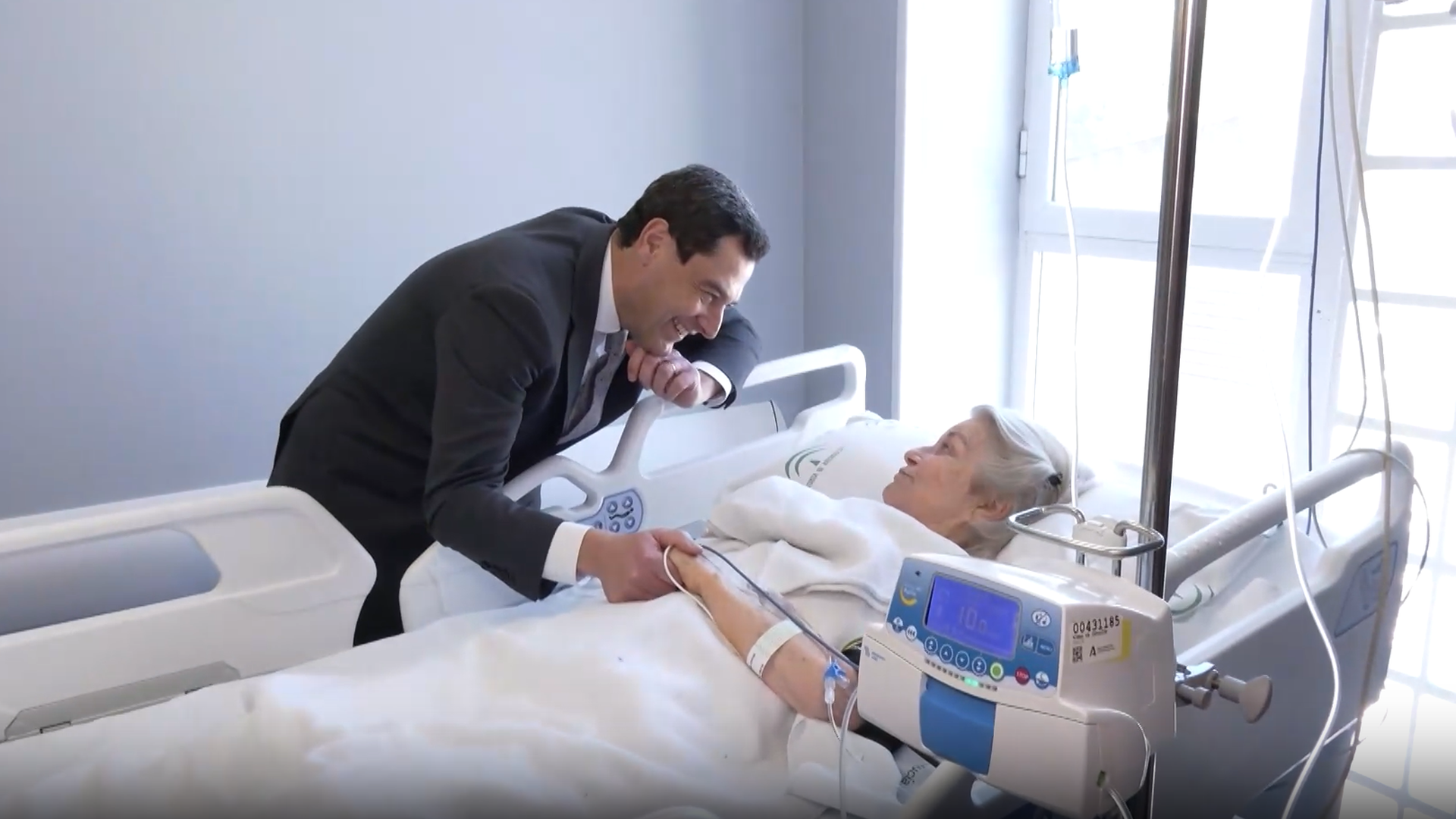 Juanma Moreno hablando con una mujer ingresada en el Virgen del Rocío