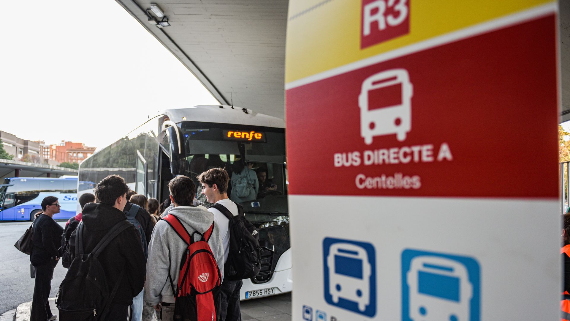 Jóvenes esperan un autobús en sustitución de la línea R3 de Rodalies Jóvenes esperan un autobús en sustitución de la línea R3 de Rodalies