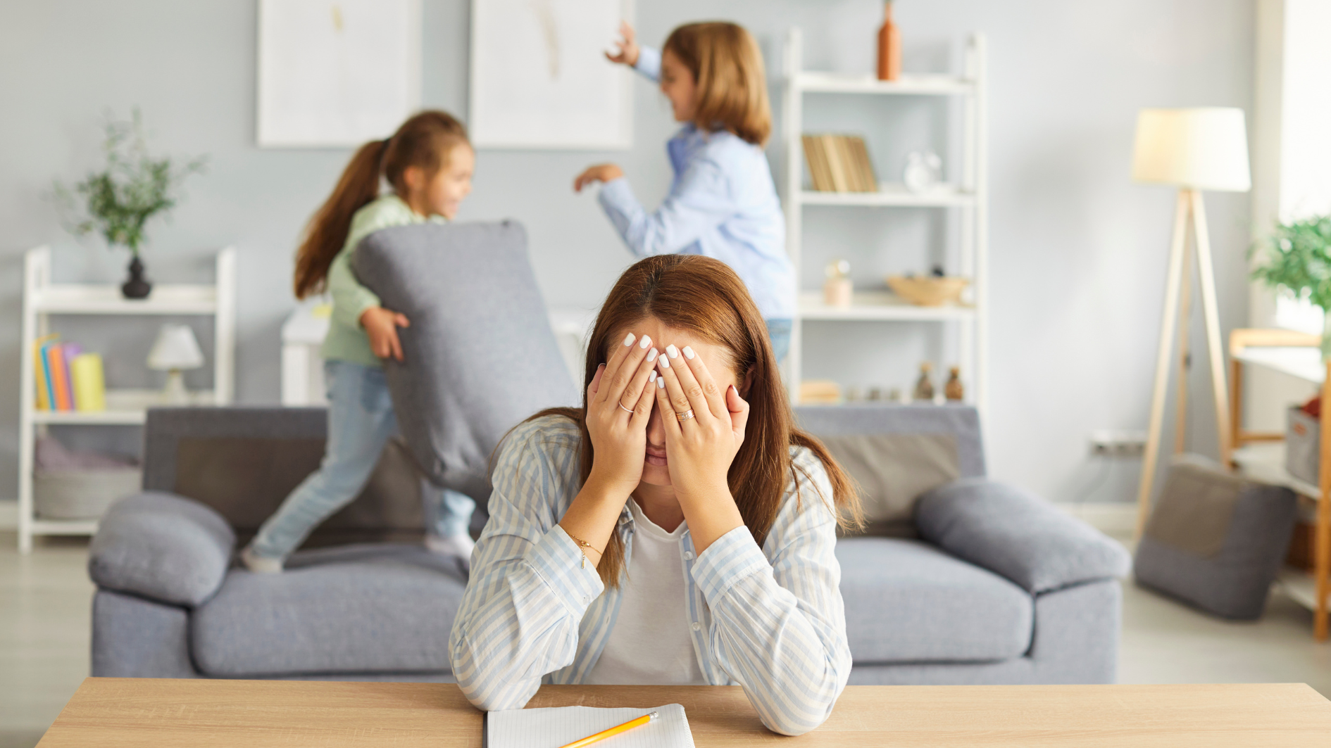 Una madre, desesperada, con sus hijos al fondo