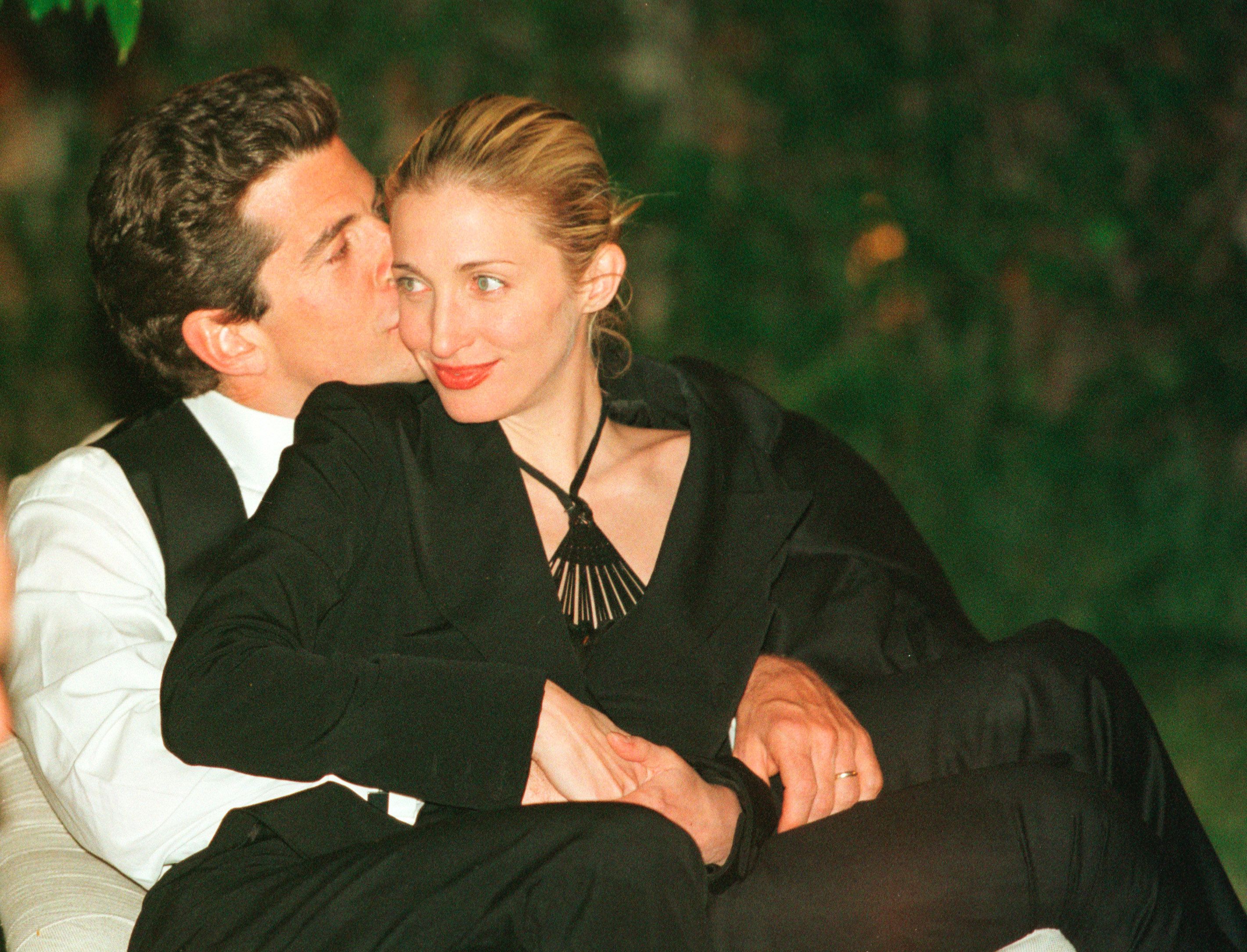 John F. Kennedy, Jr. da un beso en la mejilla a su mujer durante la cena anual de los corresponsales de la Casa Blanca, celebrada el 1 de mayo de 1999 en Washington