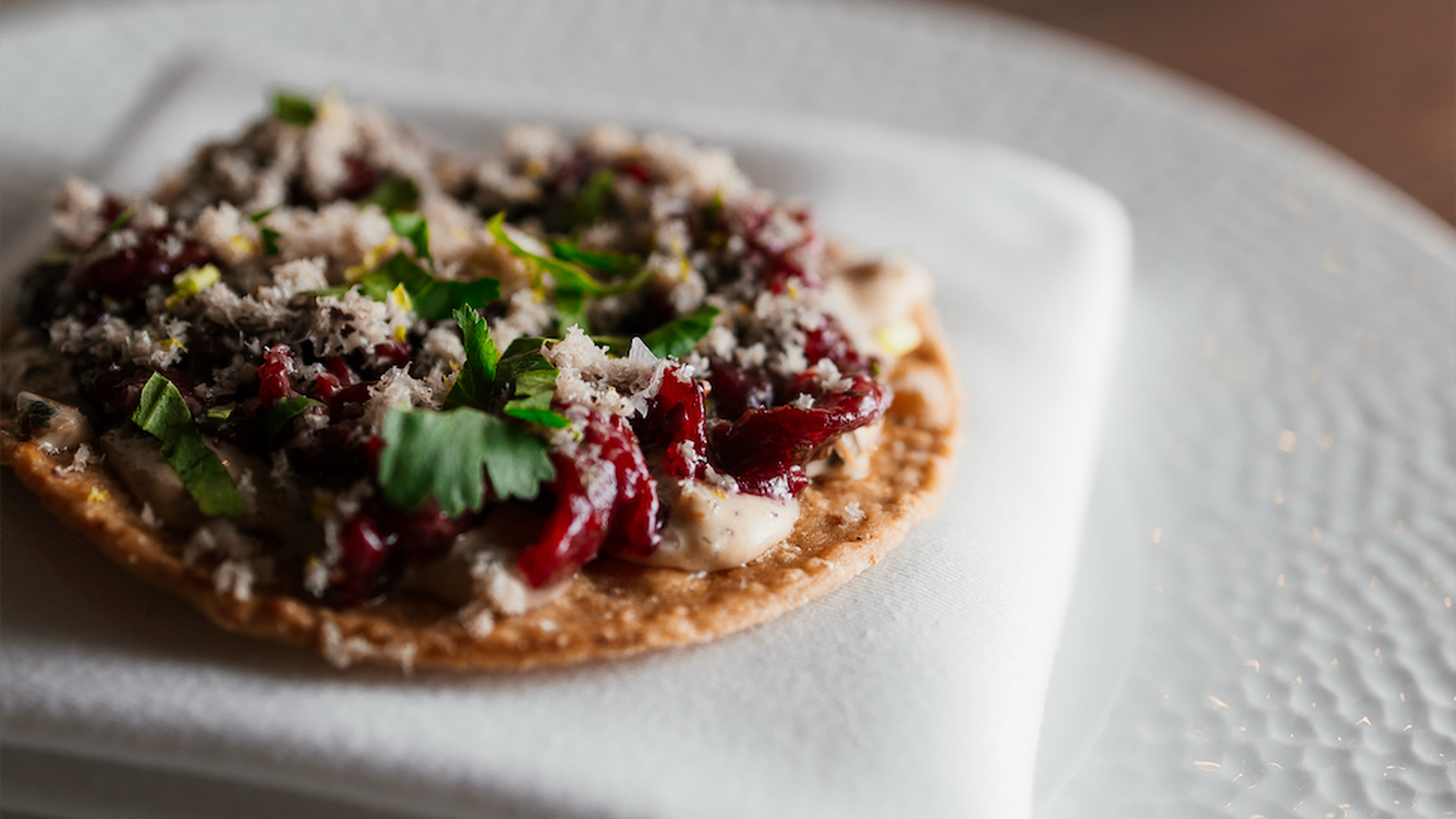 Tostada de salpicón: base de maíz frita, steak tartar de picaña madurada, mayonesa picante y tuétano rallado