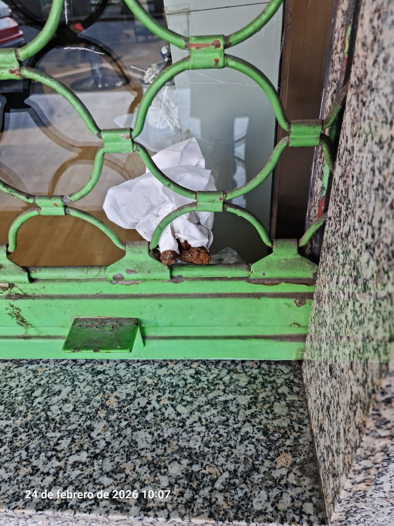 Heces introducidas con un papel en un ventanal