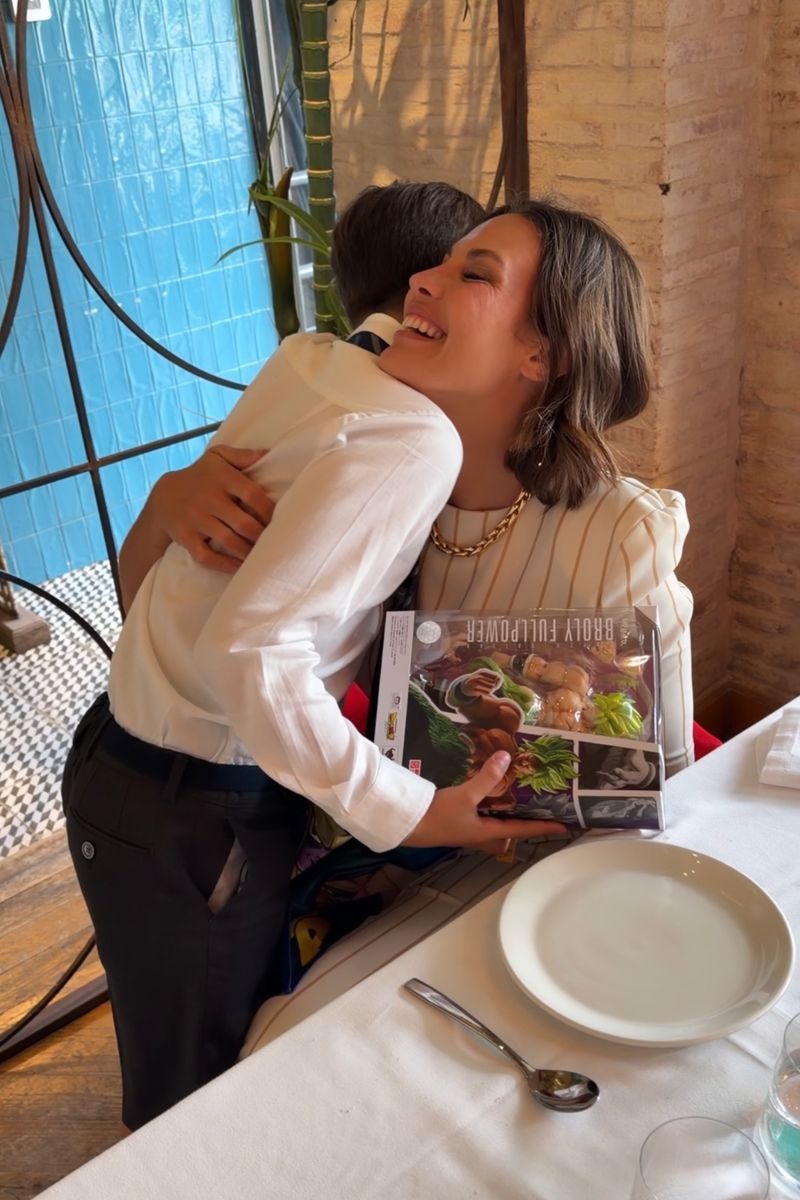 Jessica Bueno, abrazada a su hijo Jota en la comida de su comunión, tras darle un regalo