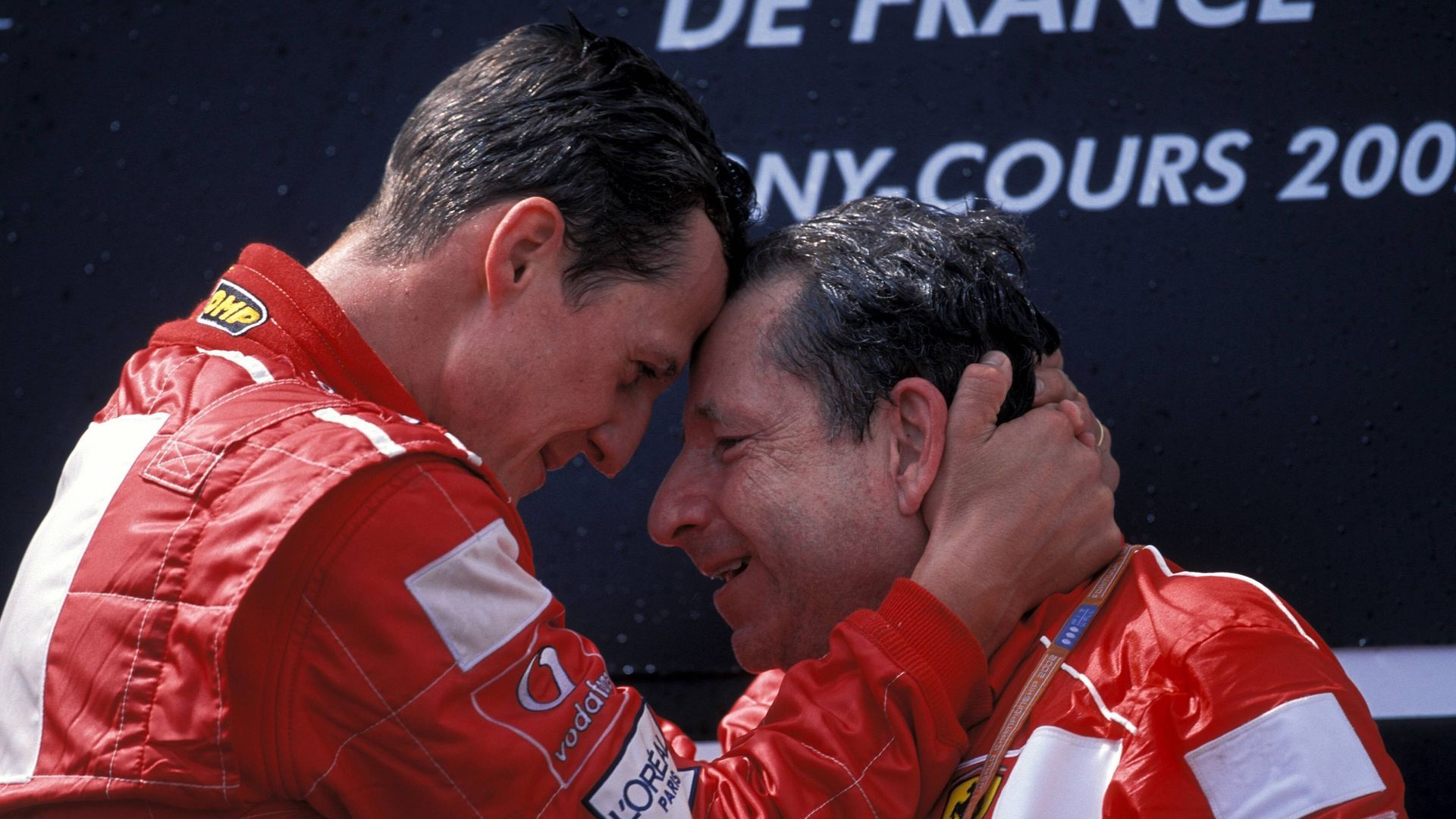Michael Schumacher y Jean Todt en el podio celebrando una victoria con Ferrari