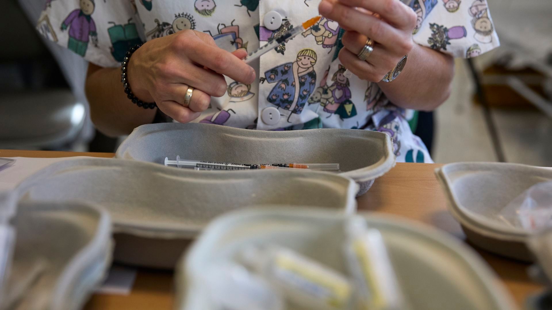 Una profesional sanitaria sostiene una jeringuilla Una profesional sanitaria sostiene una jeringuilla